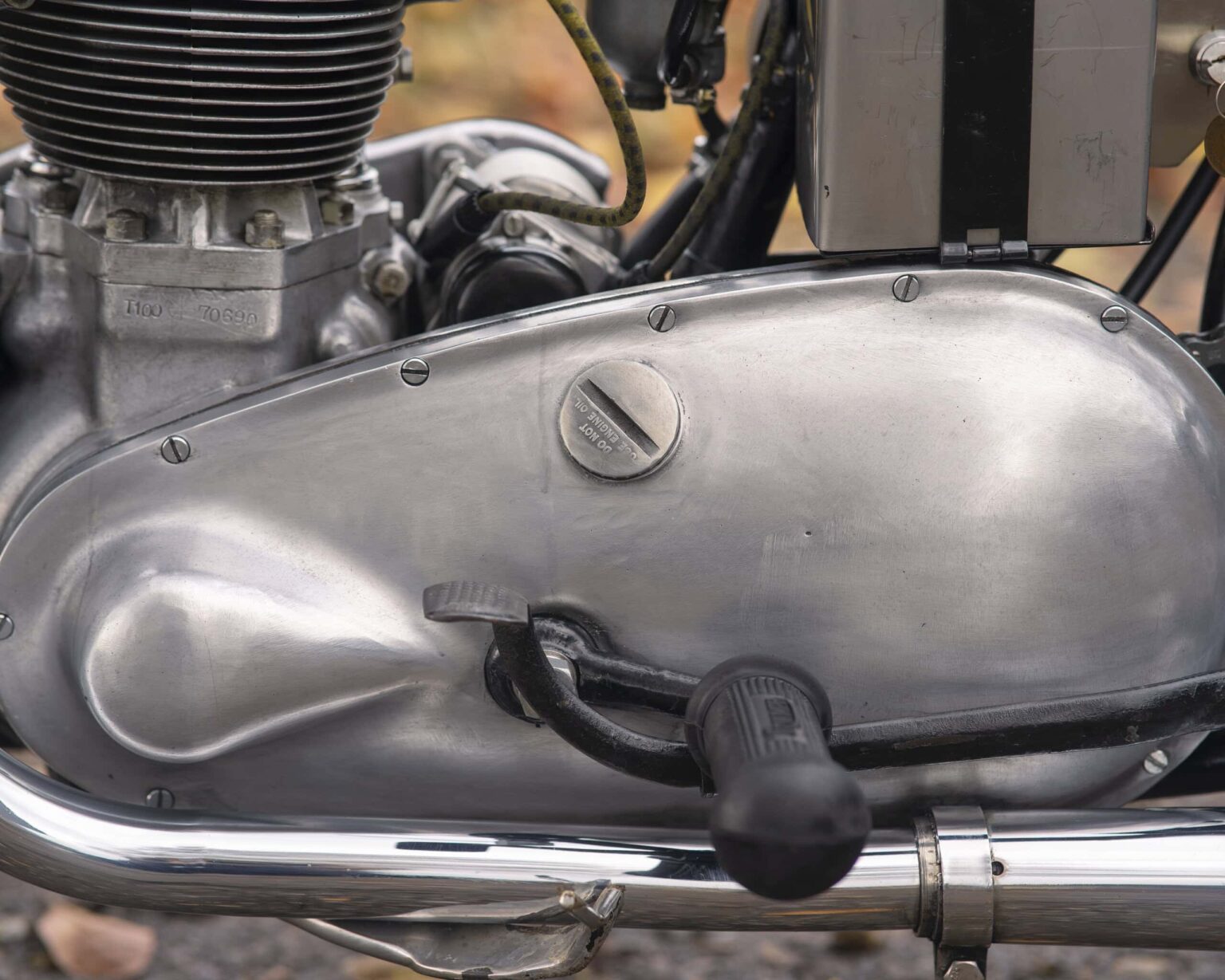 Close-up of vintage motorcycle engine with metal casing, bolts, and mechanical details.