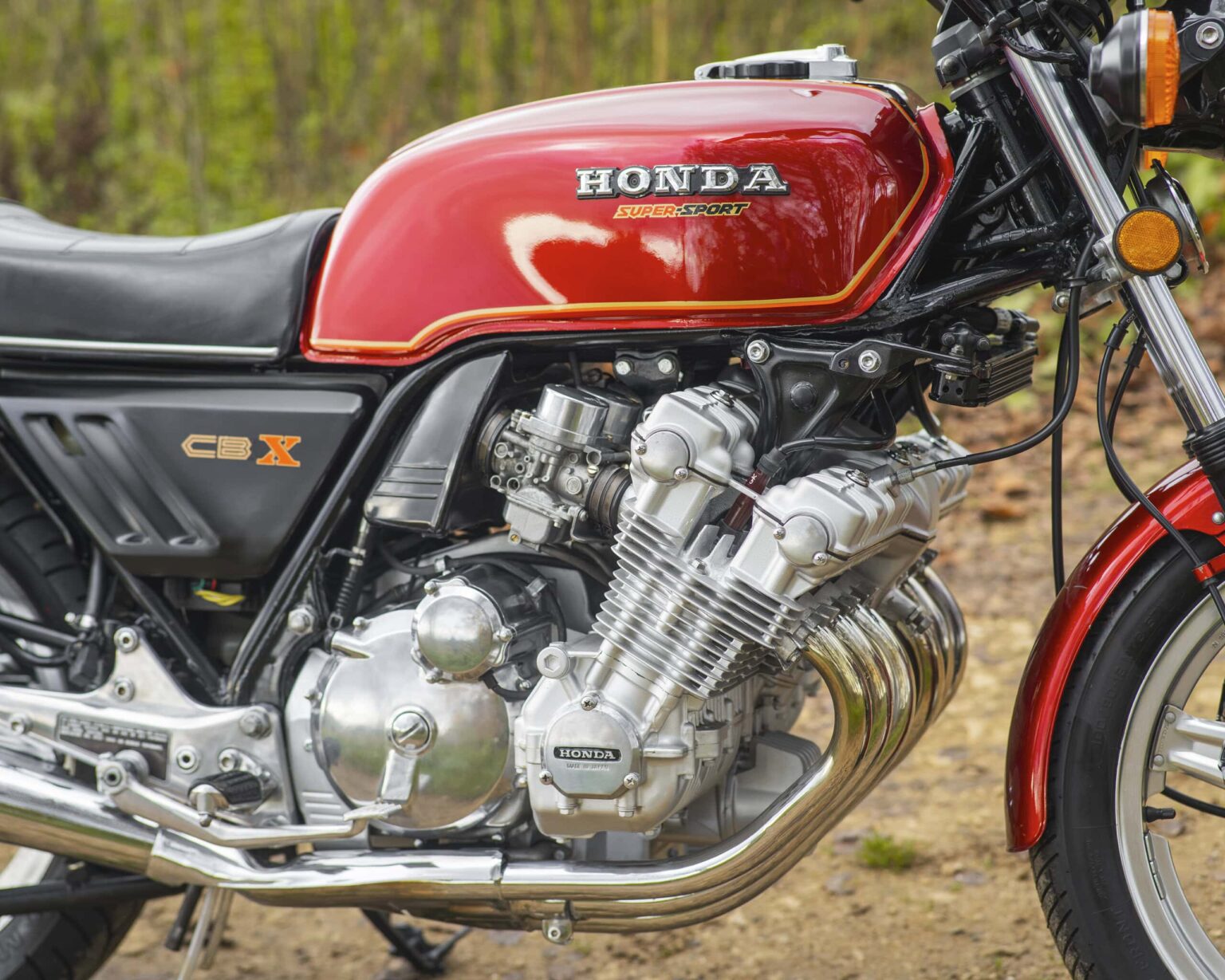 Classic Honda CBX motorcycle with red fuel tank and chrome engine details.