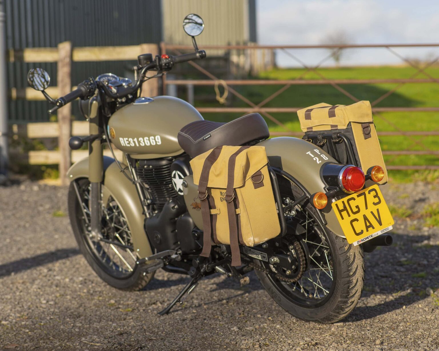 Motorcycle with tan saddlebags parked outdoors, ready for classic competition events.
