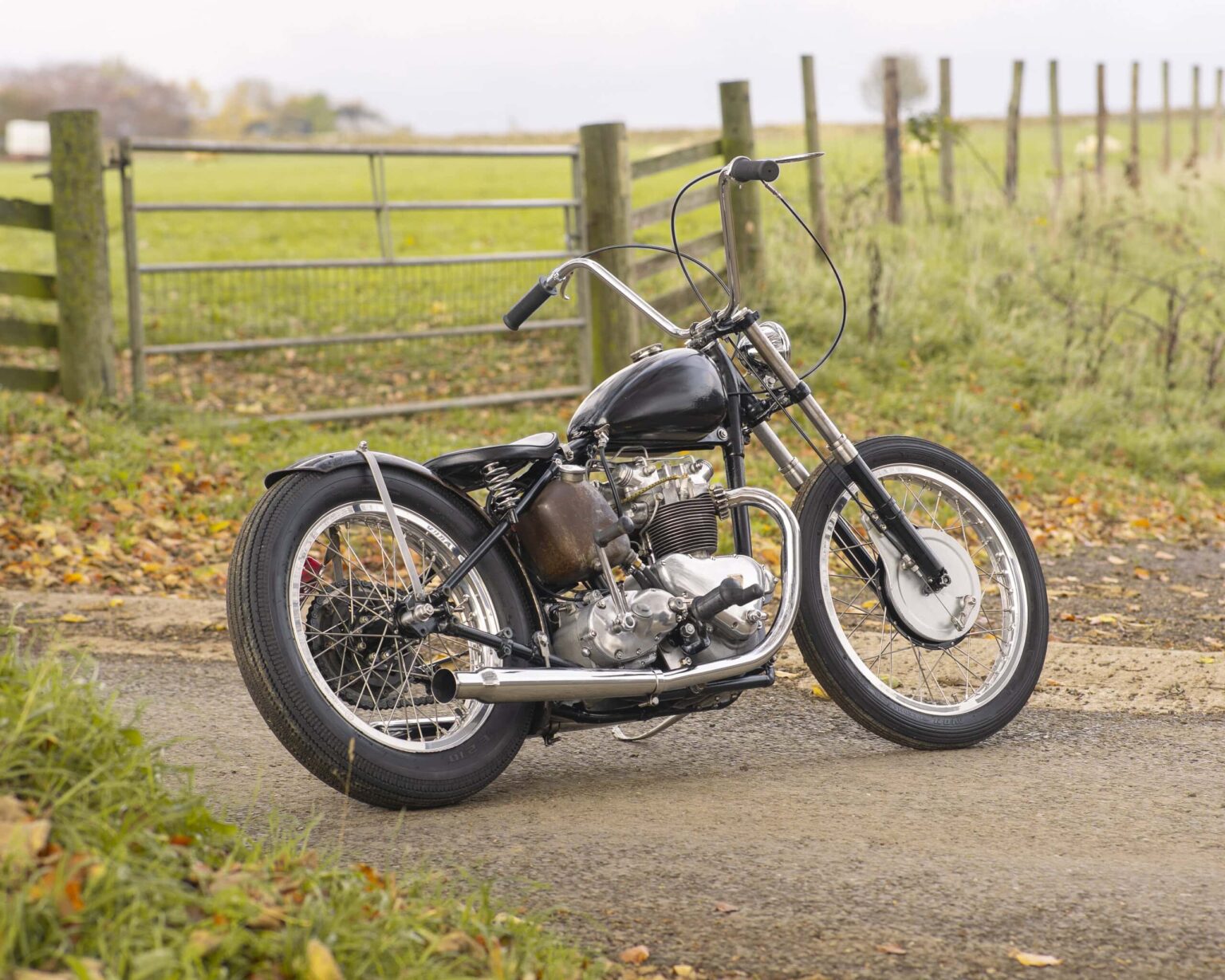 Classic vintage motorcycle on rural dirt road, ideal for collectors and vintage vehicle lovers.