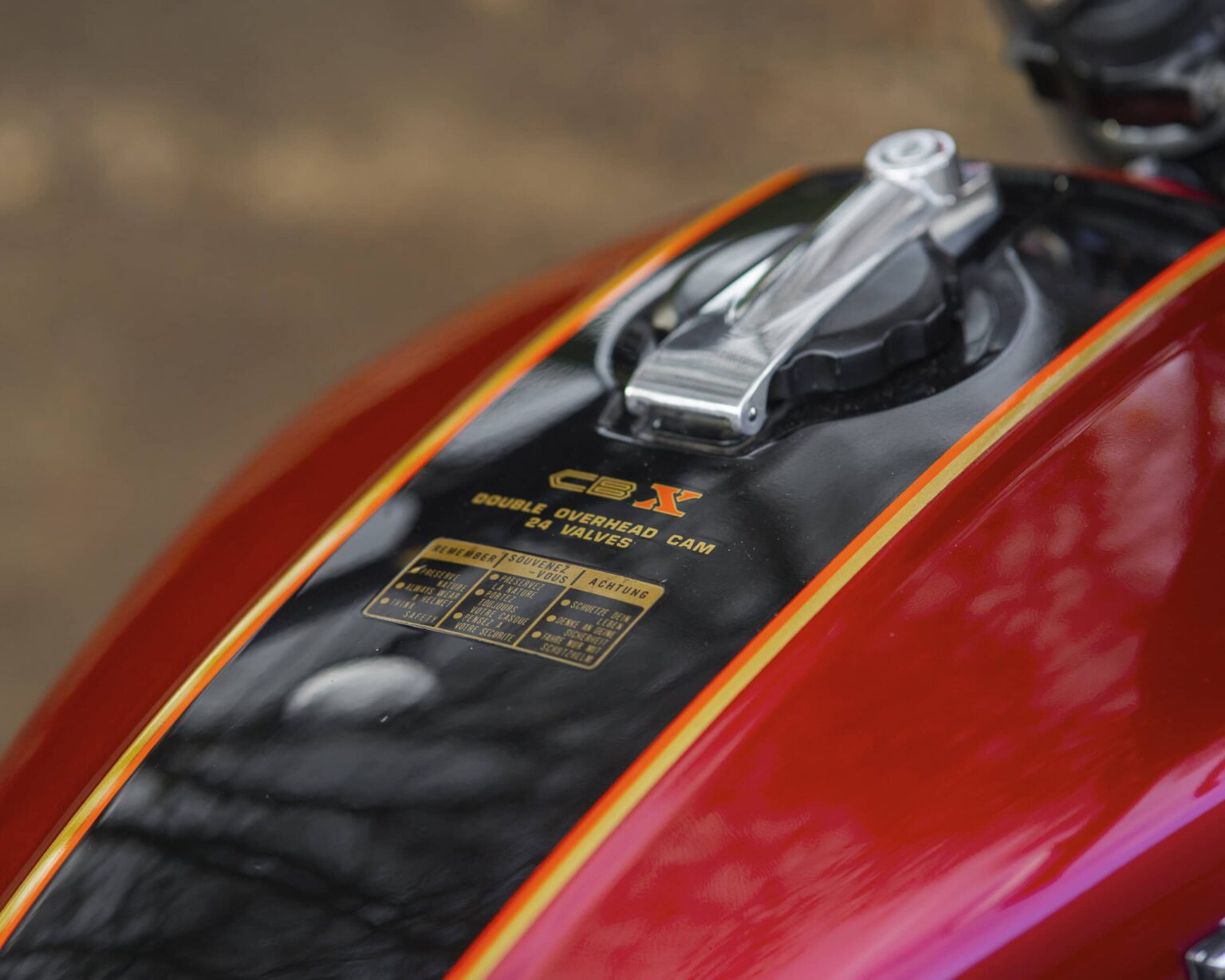 Up of a motorcycle fuel tank featuring racing decals and a sleek design.
