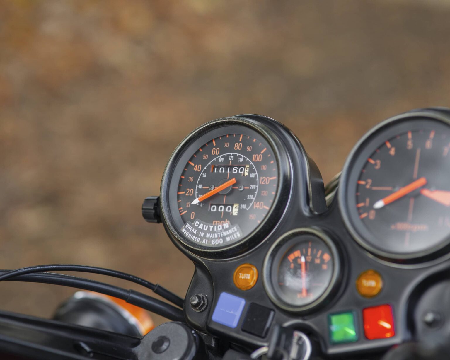 Close-up of a motorcycle speedometer and dashboard gauges.
