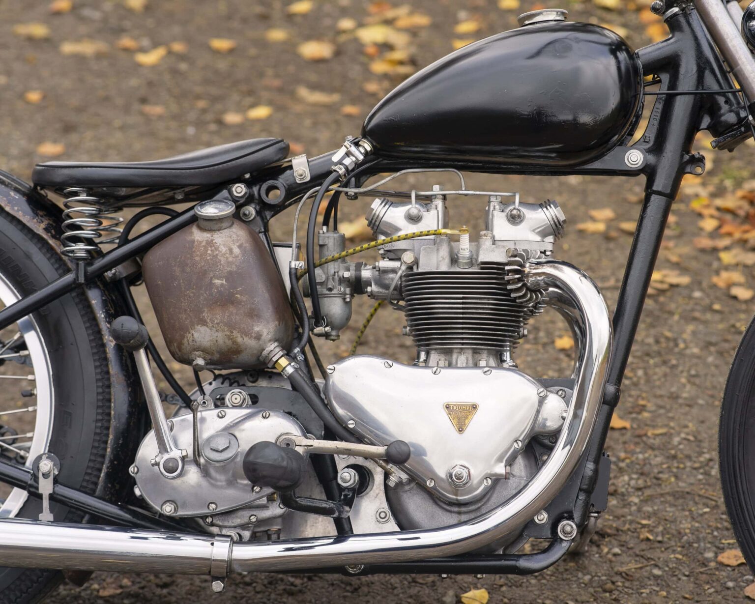 Close-up of vintage motorcycle engine showing rusted tank and polished components. Perfect for classic motorcycle enthusiasts.