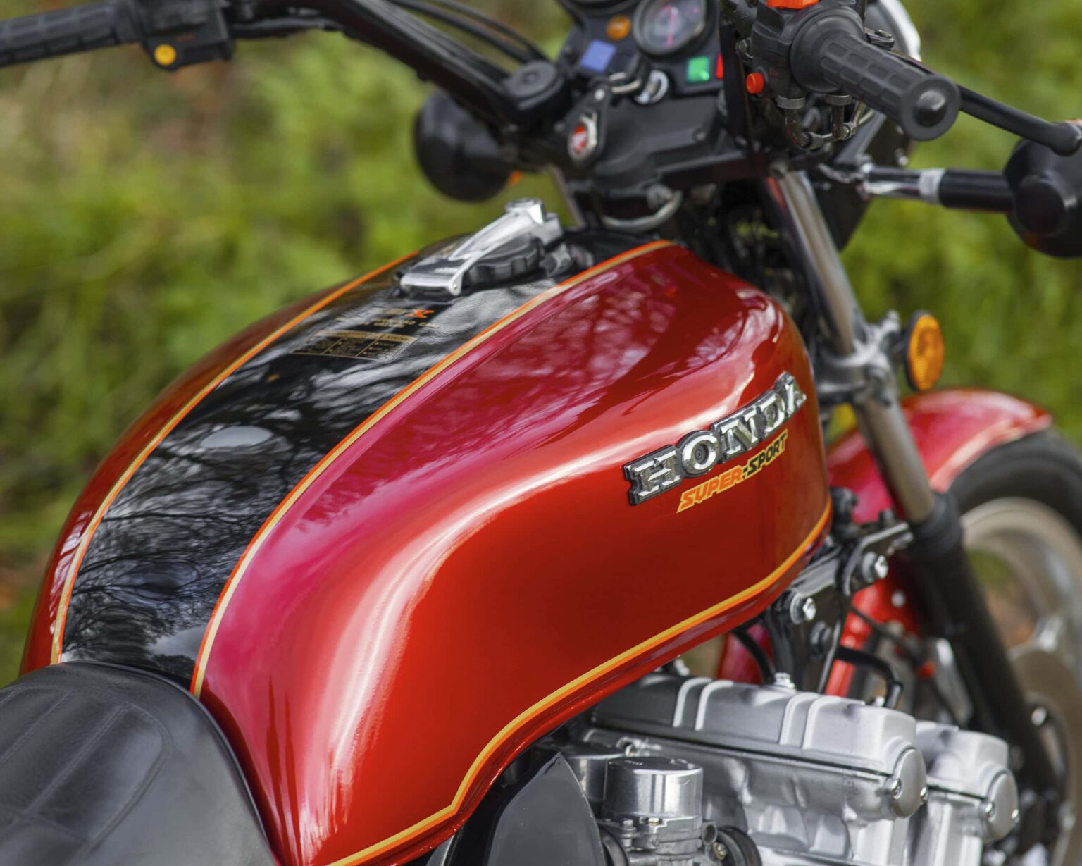 Honda Super Cub motorcycle with a red fuel tank and black accents.