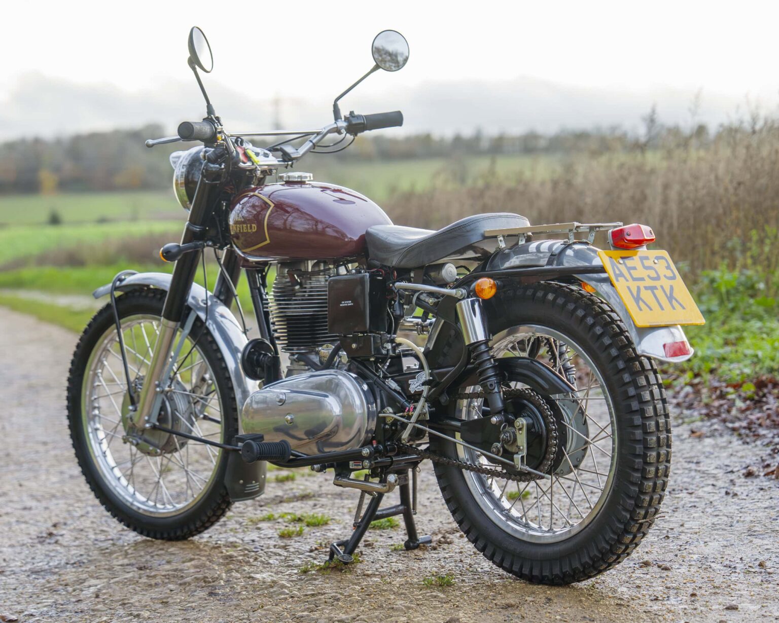 Classic motorcycle with a maroon fuel tank and chrome details.