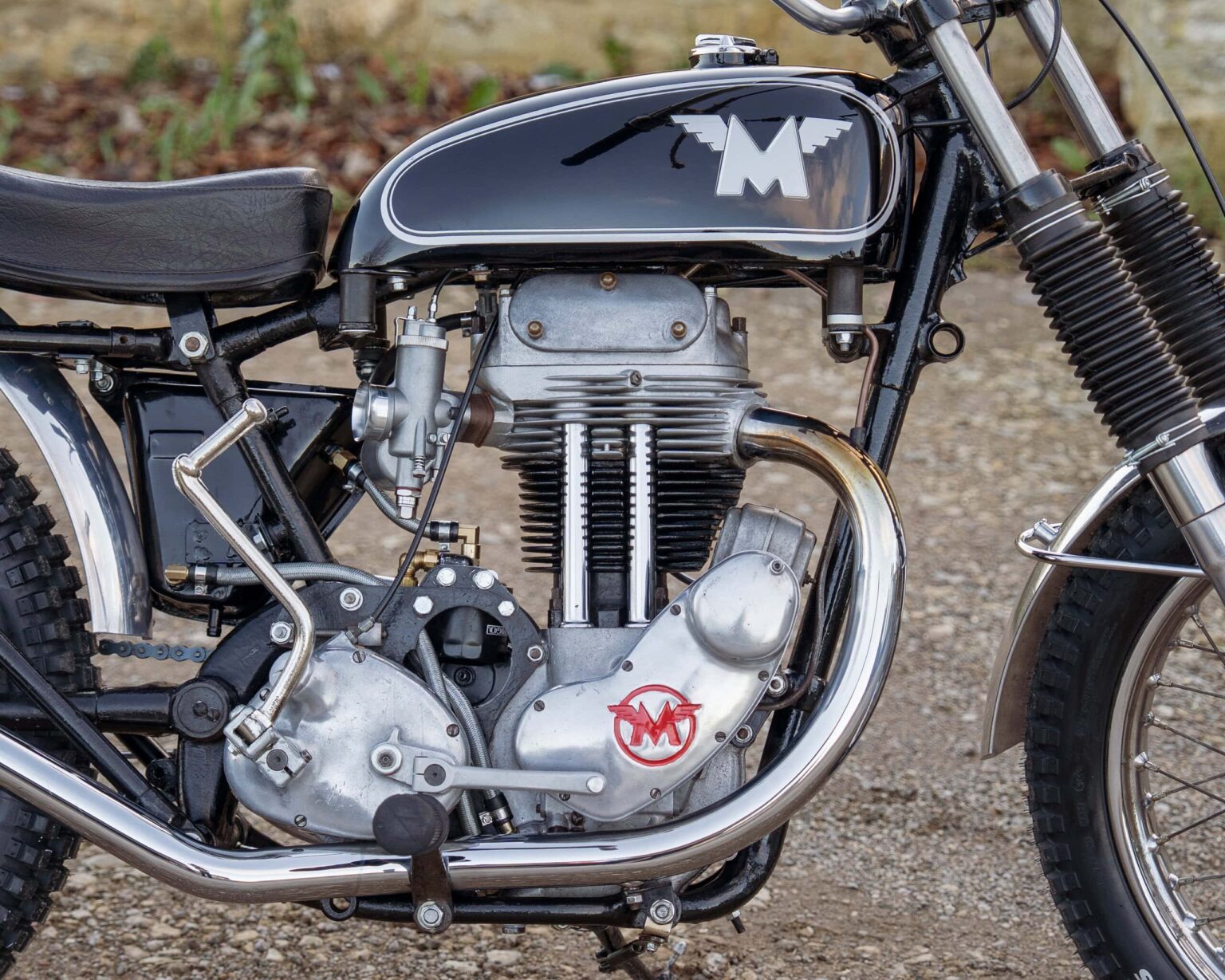 Close-up of a vintage racing motorcycle engine with distinctive logo, chrome and black accents.