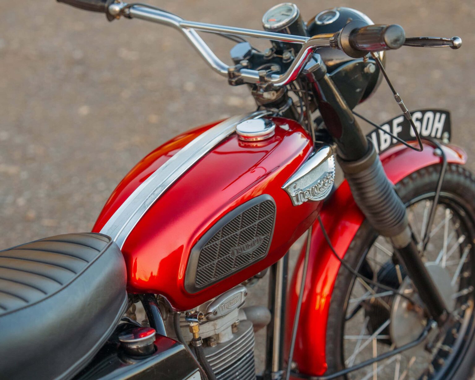 Motorcycle with red fuel tank and vintage design at The Classic Competition Company.