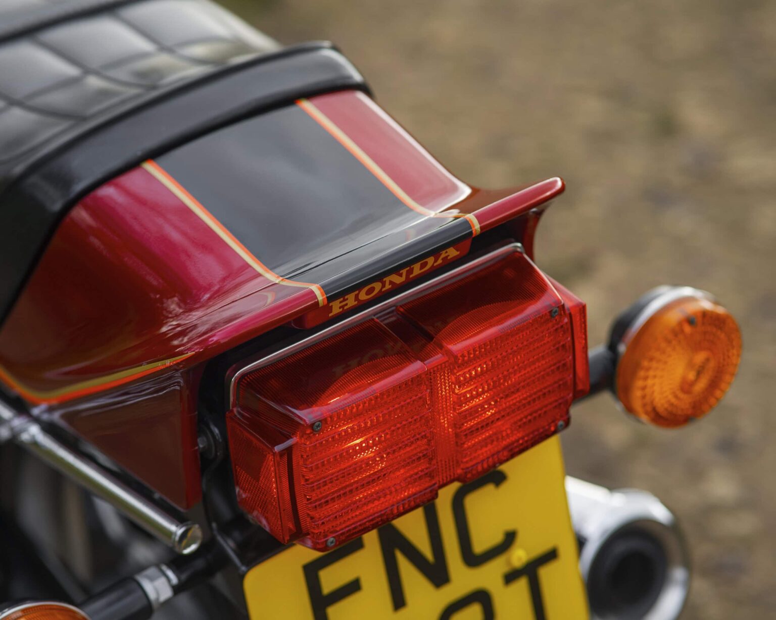 Close-up of a vintage Honda motorcycle rear light and indicators.