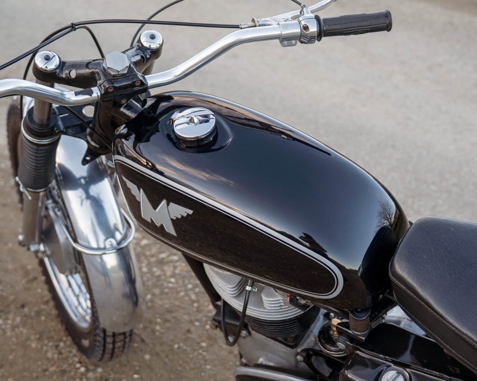 A vintage BMW motorcycle showcasing a sleek black fuel tank with chrome accents and classic design details.