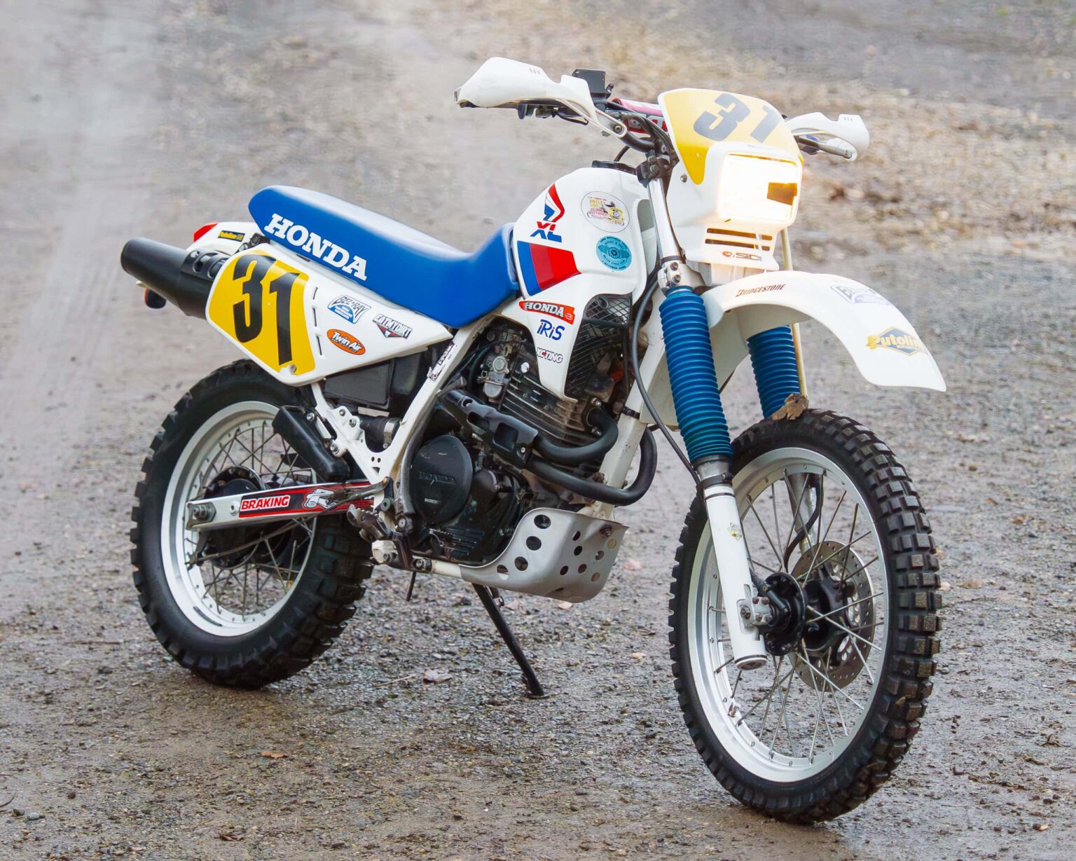 Classic Honda dirt bike with racing decals and number 31. Designed for vintage motorcycle competitio.