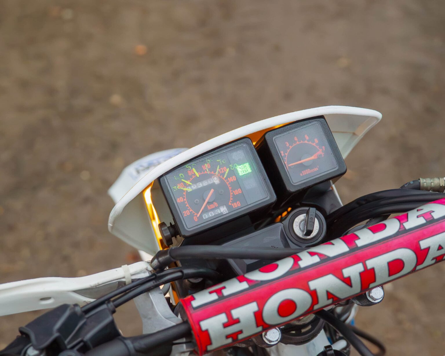 Up of Honda CRF motorcycle dashboard with speedometer and tachometer.