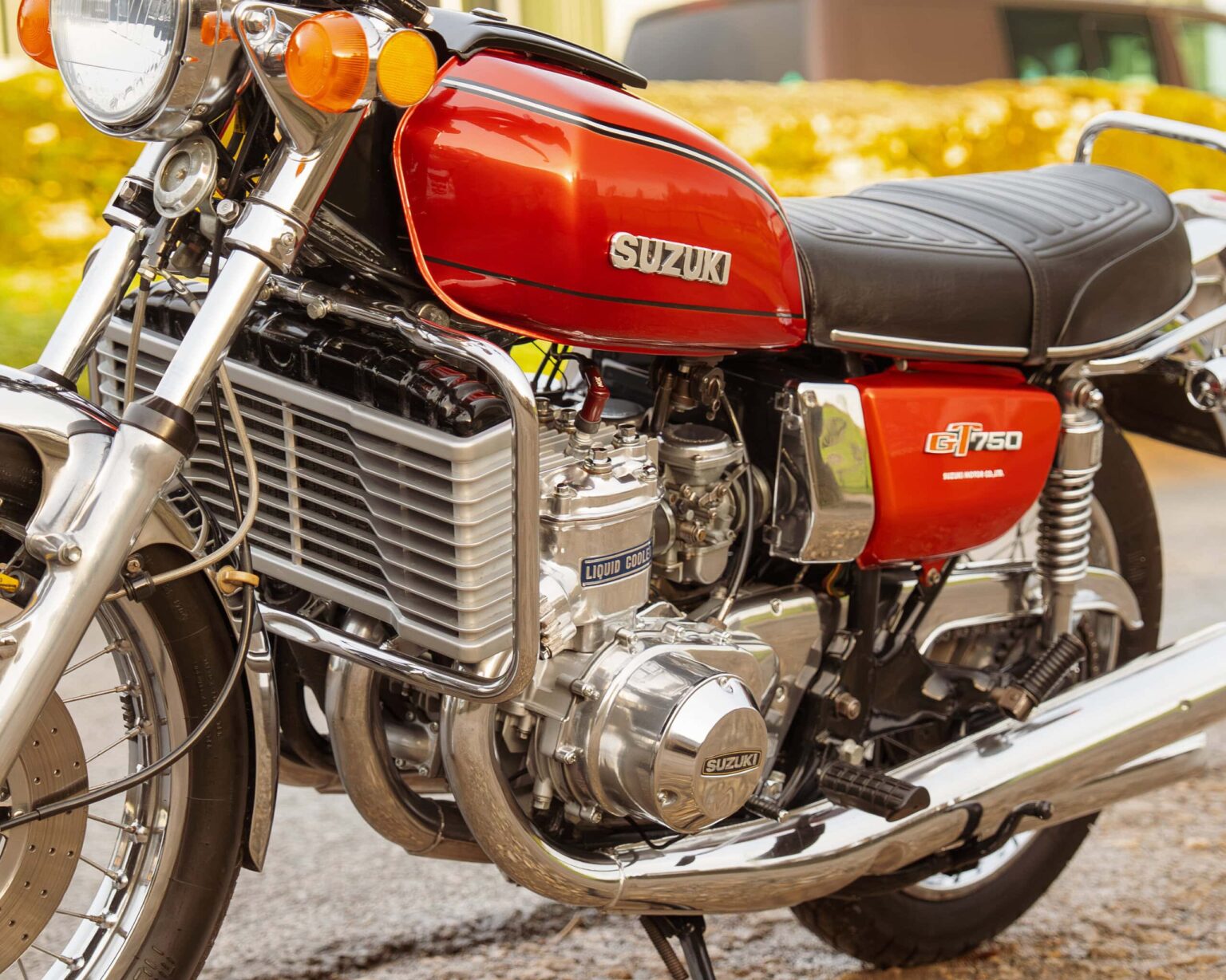 Close-up of a red Suzuki GT750 motorcycle engine showcasing classic vintage design and chrome details.