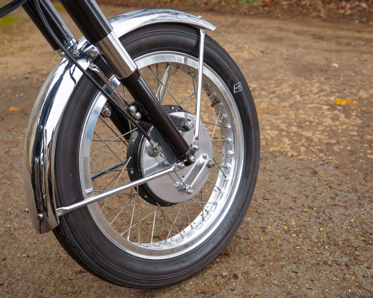 Close-up of a vintage motorcycle front wheel and suspension system for classic bike enthusiasts.