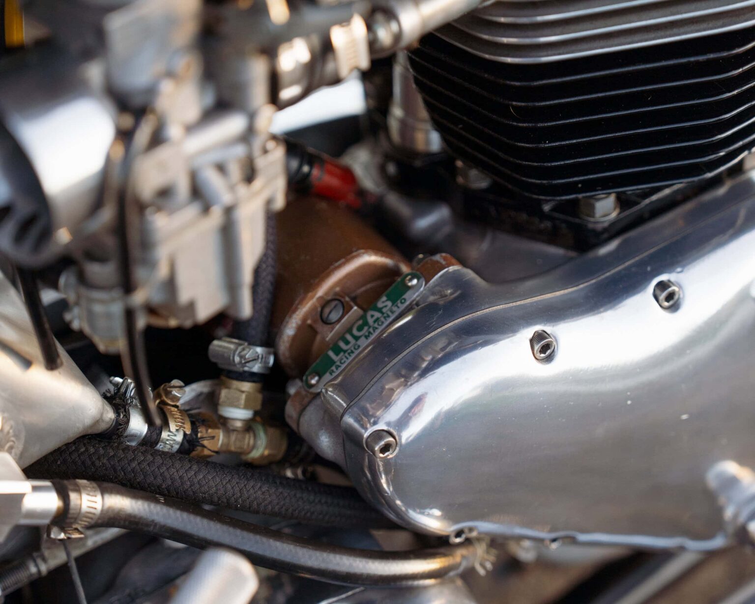 Close-up of a vintage racing engine with Lucas Racing branded parts and detailed mechanical fittings.
