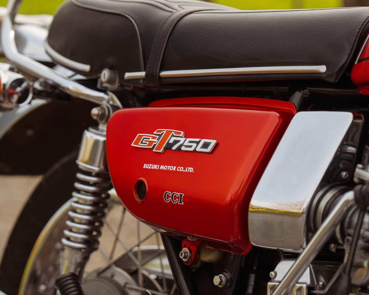 Detailed image of vintage Suzuki GT750 engine and red side panel.