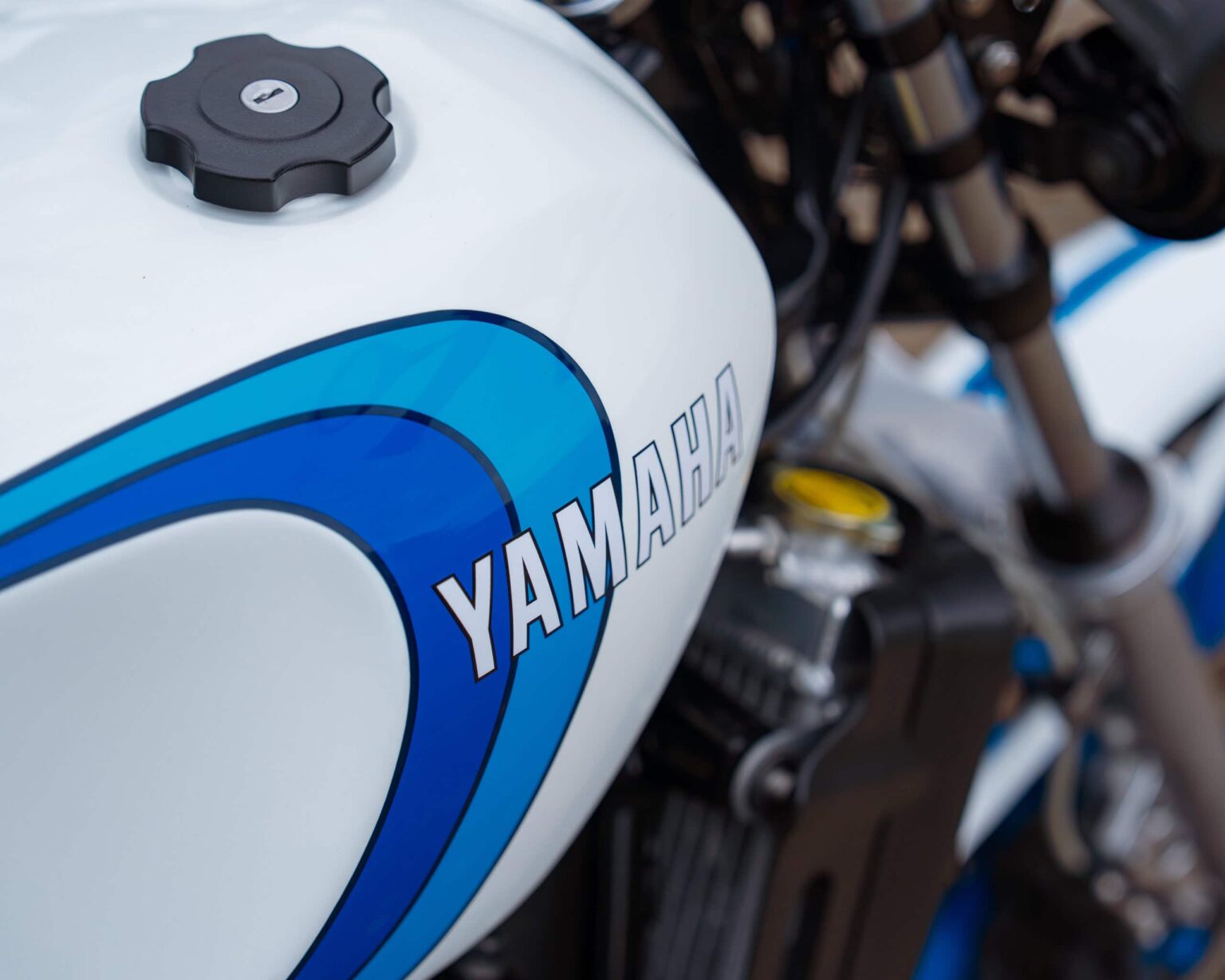 Close-up of a Yamaha motorcycle fuel tank with iconic branding and cap.