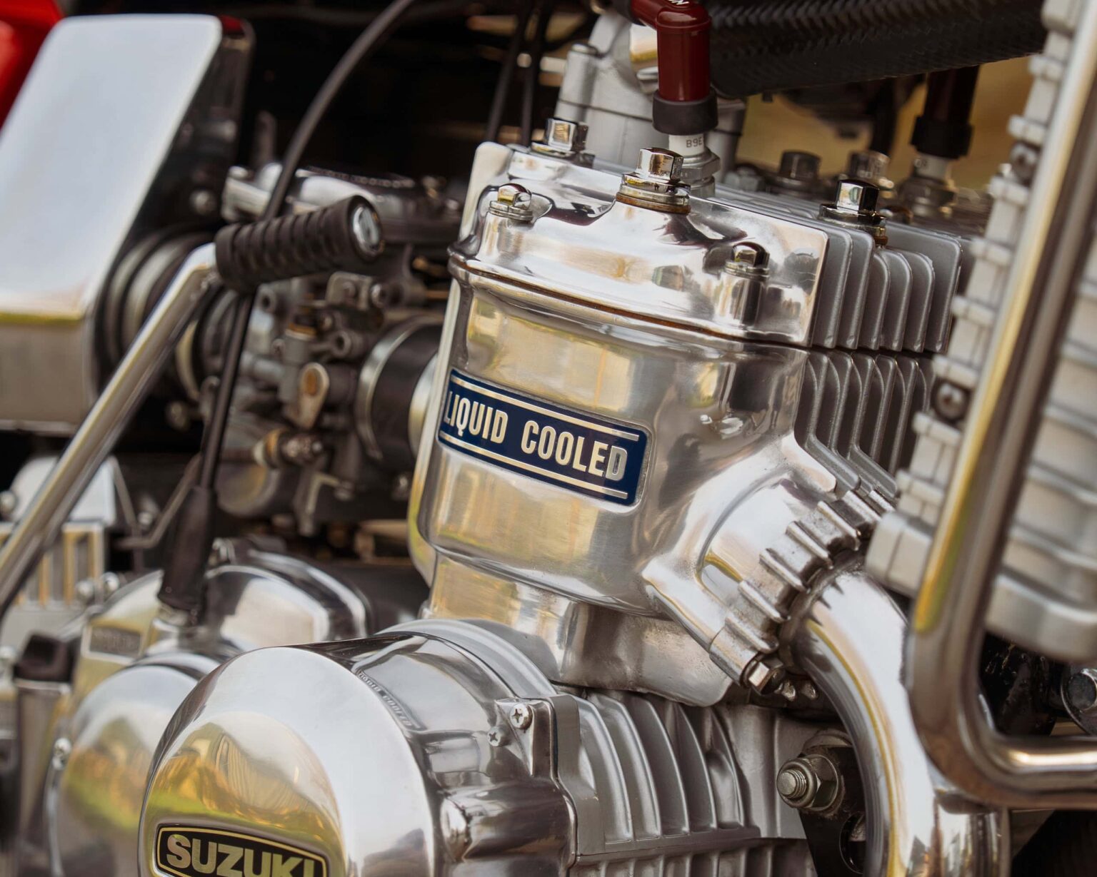 Close-up of a high-performance motorcycle engine with "Liquid Cooled" label and detailed metal parts.