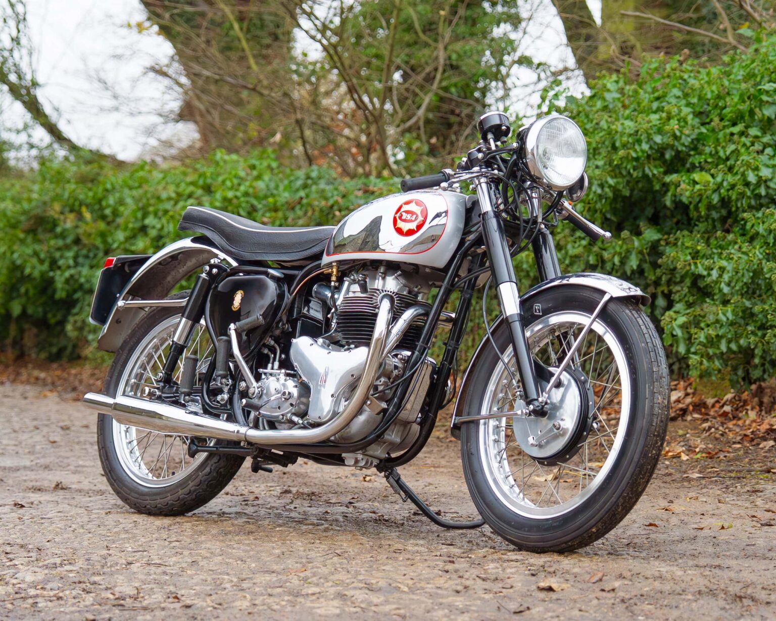 Vintage BSA motorcycle with chrome details on a country road.