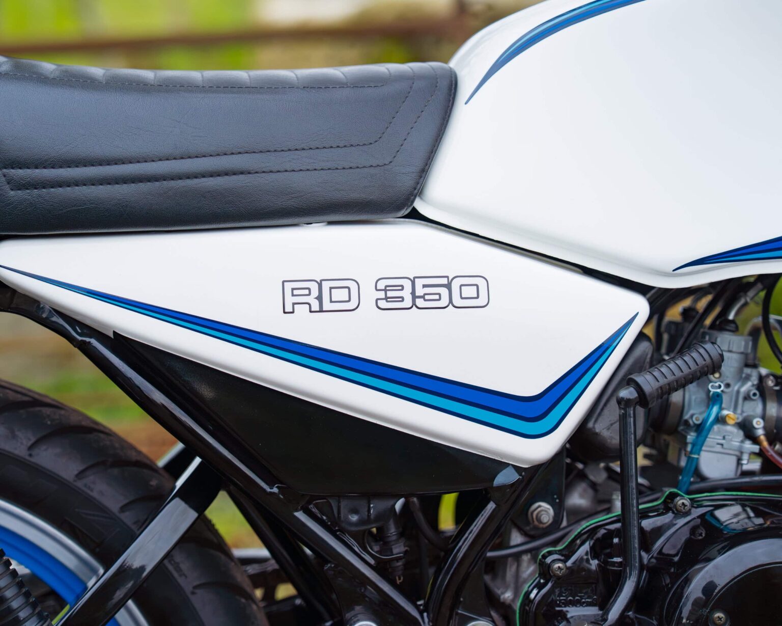 Close-up of a white and blue RD 350 motorcycle detailing.