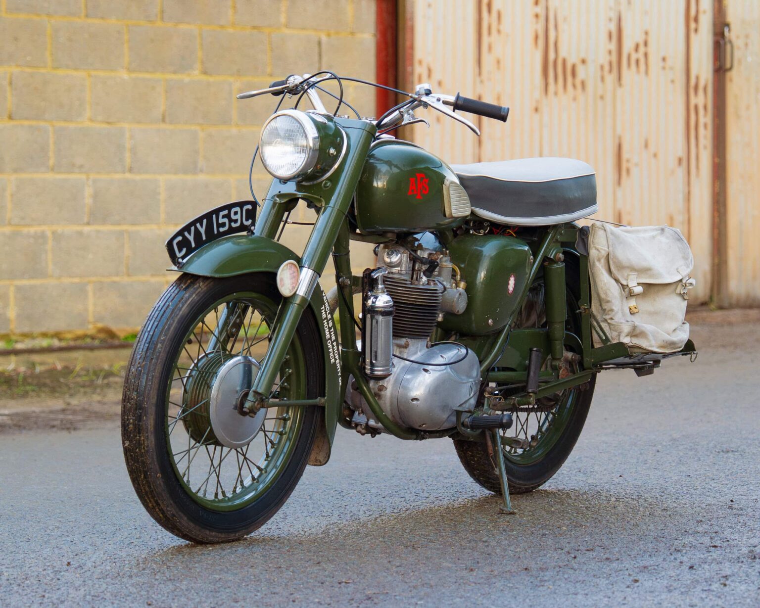 Vintage military motorcycle with side panniers, parked on street.
