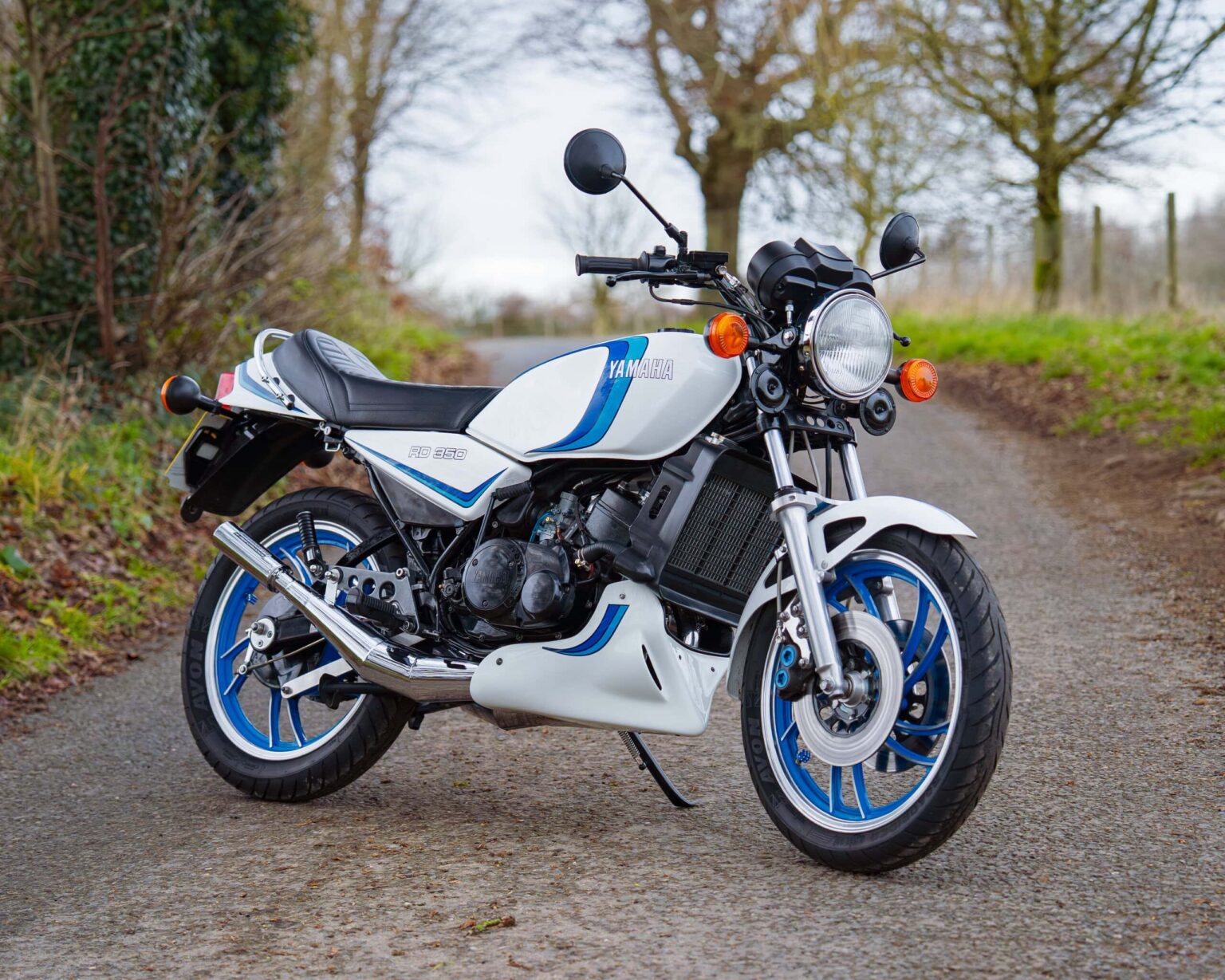 Classic Yamaha RD 350 bike with retro styling on a rural road.