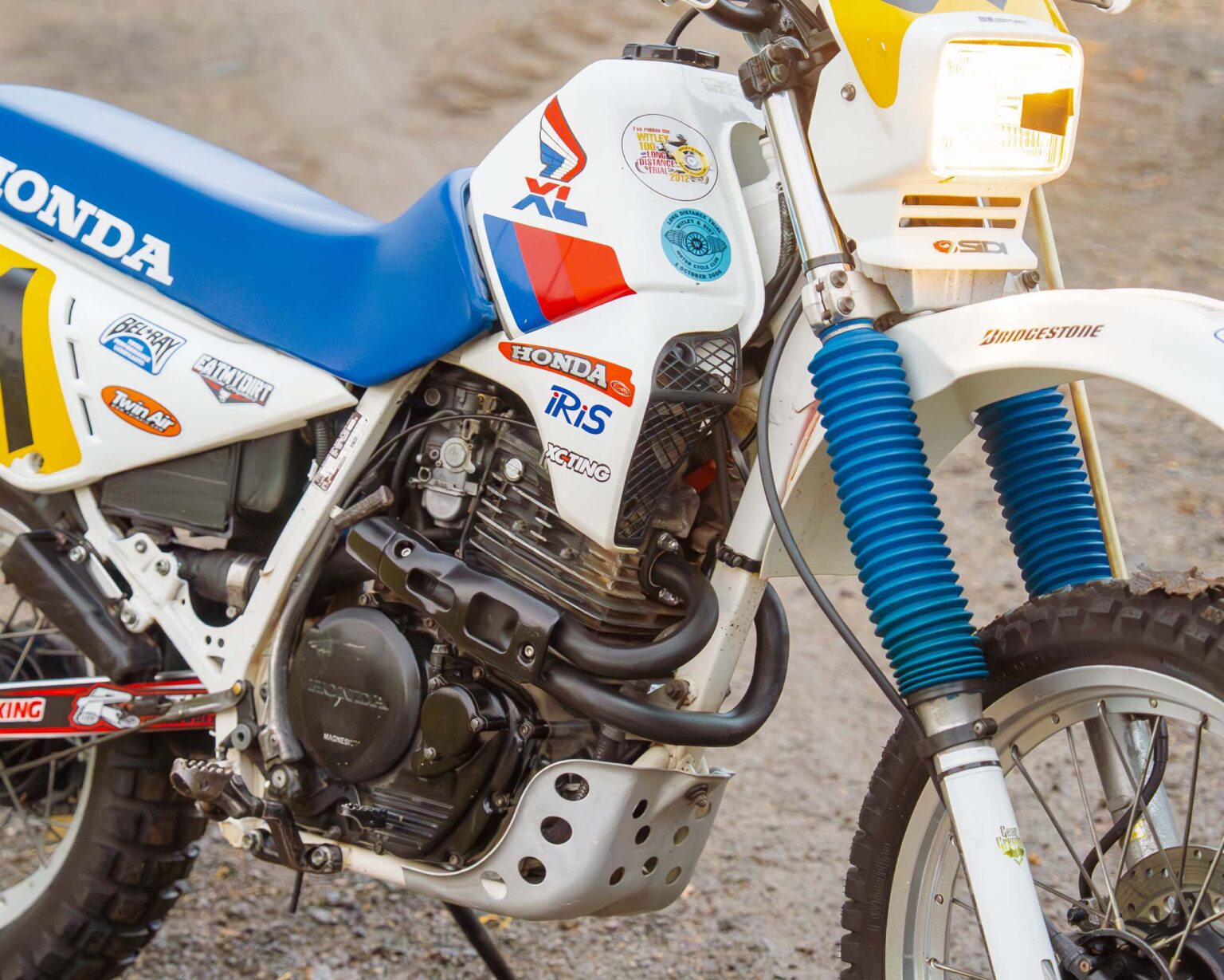 Classic Honda XR dirt bike with vintage decals and blue suspension forks.