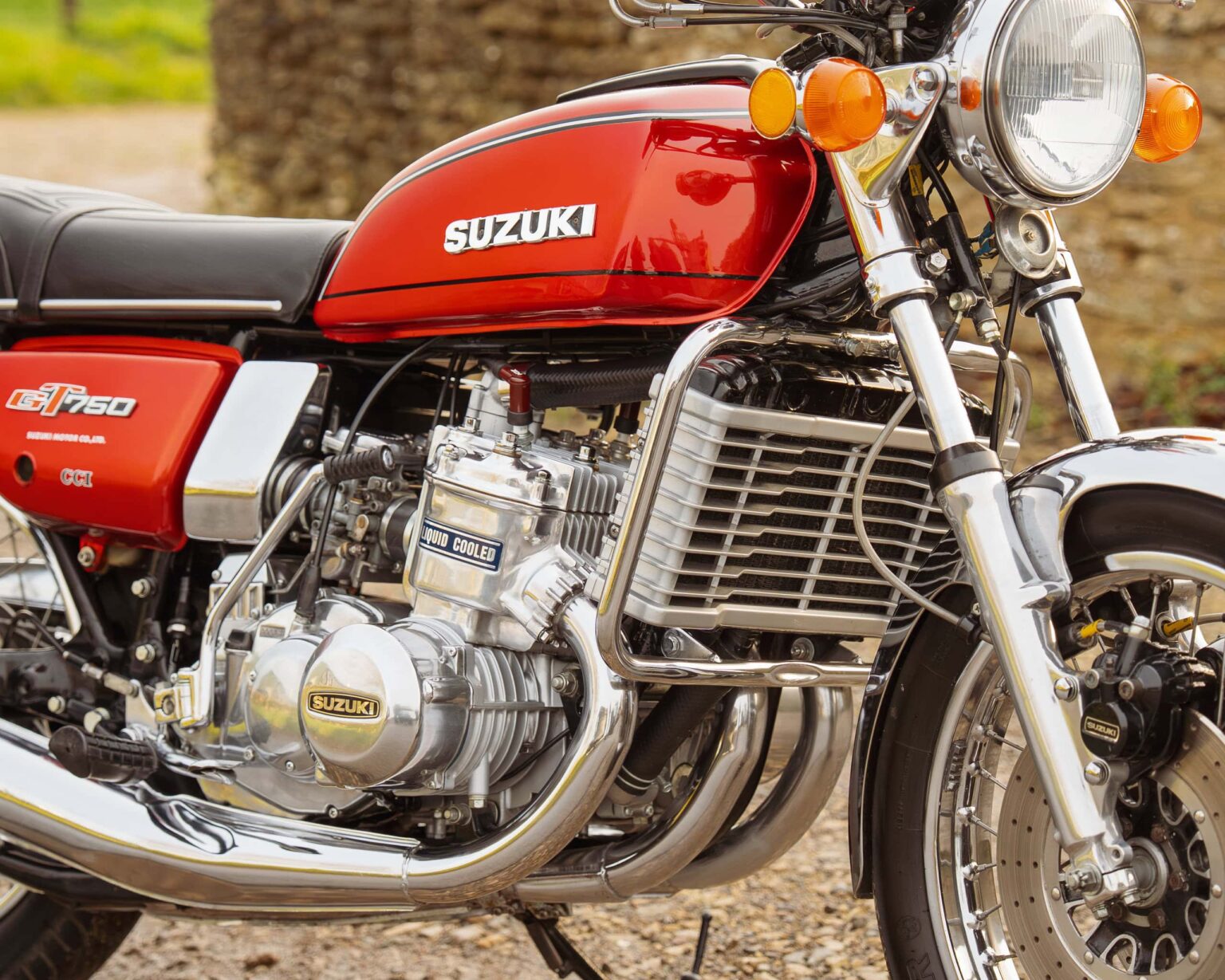 Close-up of a classic red Suzuki GT750 with chrome details and engine components.