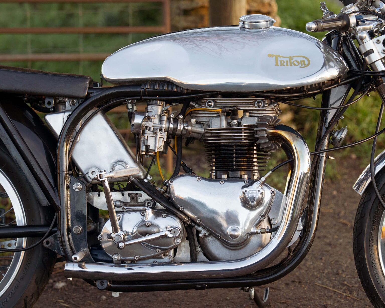 High-resolution close-up of a vintage Triumph motorcycle engine with metal finish and black components.