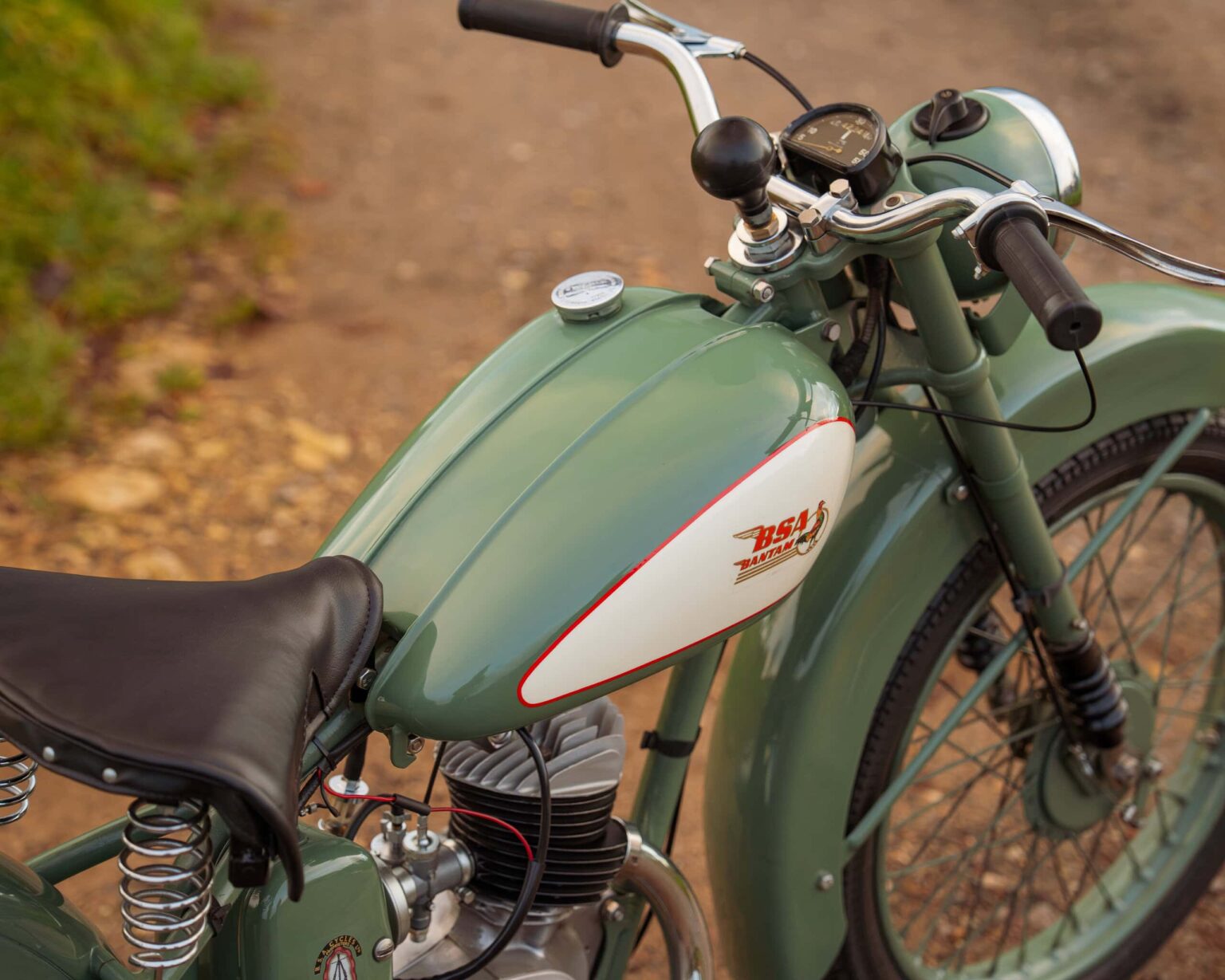 Vintage motorcycle with green and white paint, classic design, and retro features.