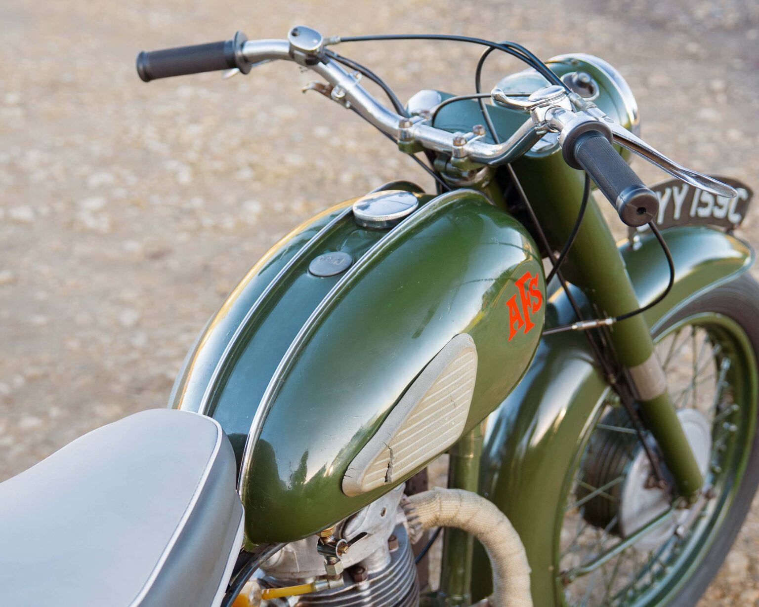 Vintage motorcycle with green paint and retro design.