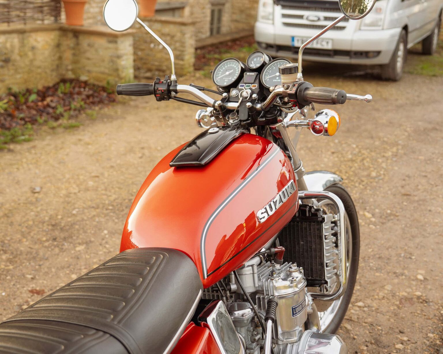 Suzuki vintage motorcycle with chrome and black details, classic handlebars, and red fuel tank, ideal for vintage motorcycle enthusiasts.