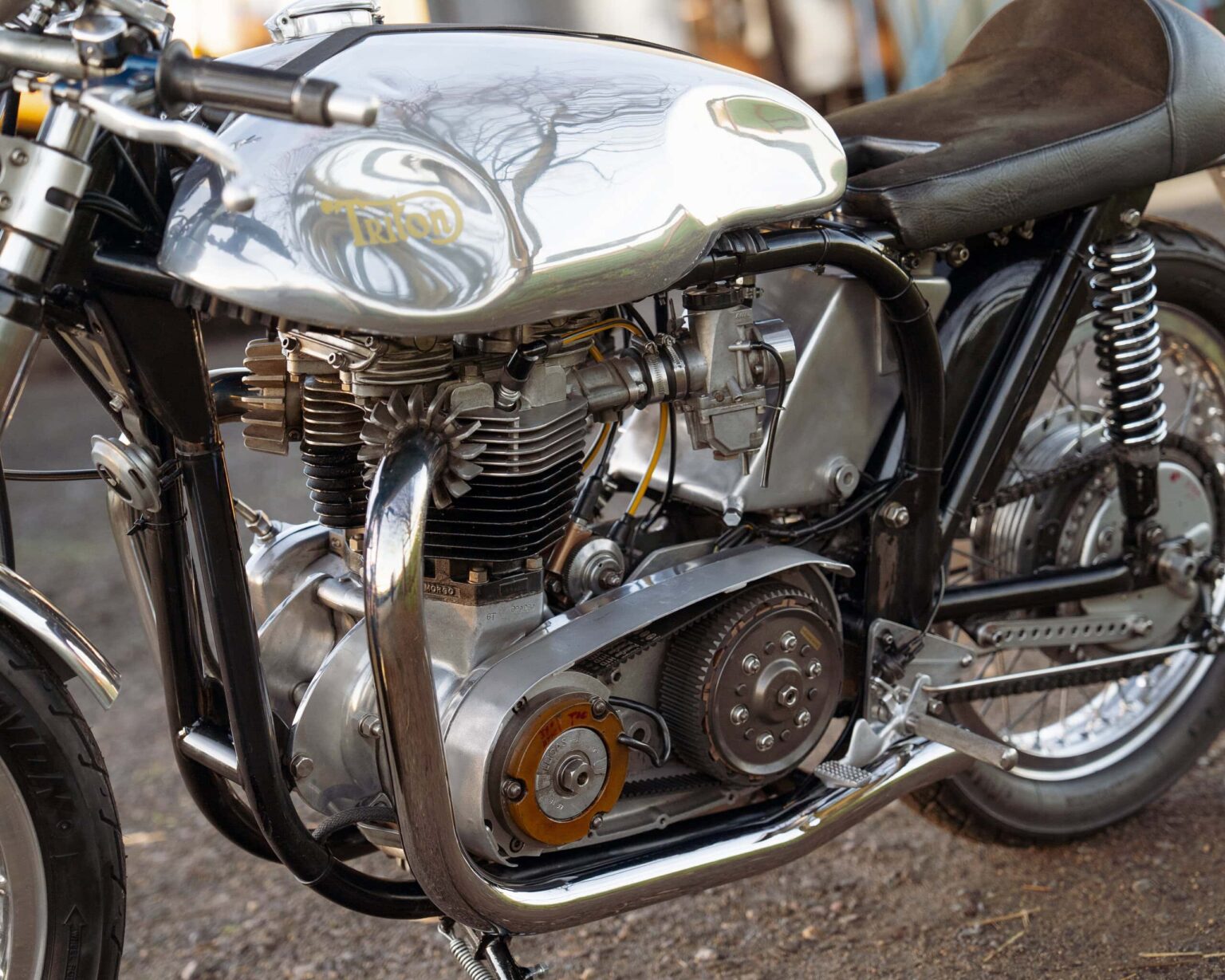 Vintage Triumph motorcycle engine with polished metal finish and black frame.