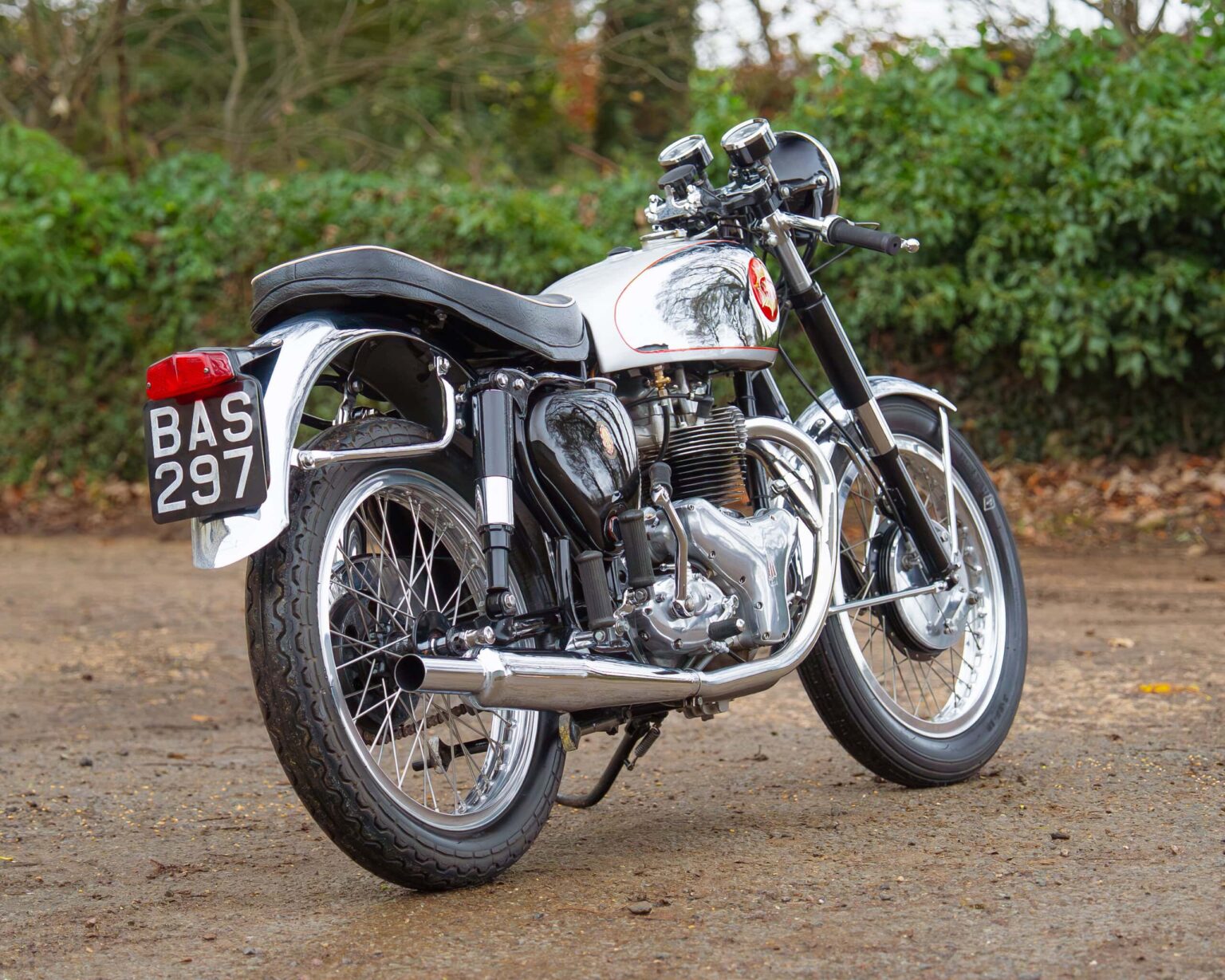 Classic motorcycle with chrome details, black and white colour scheme, and vintage style.