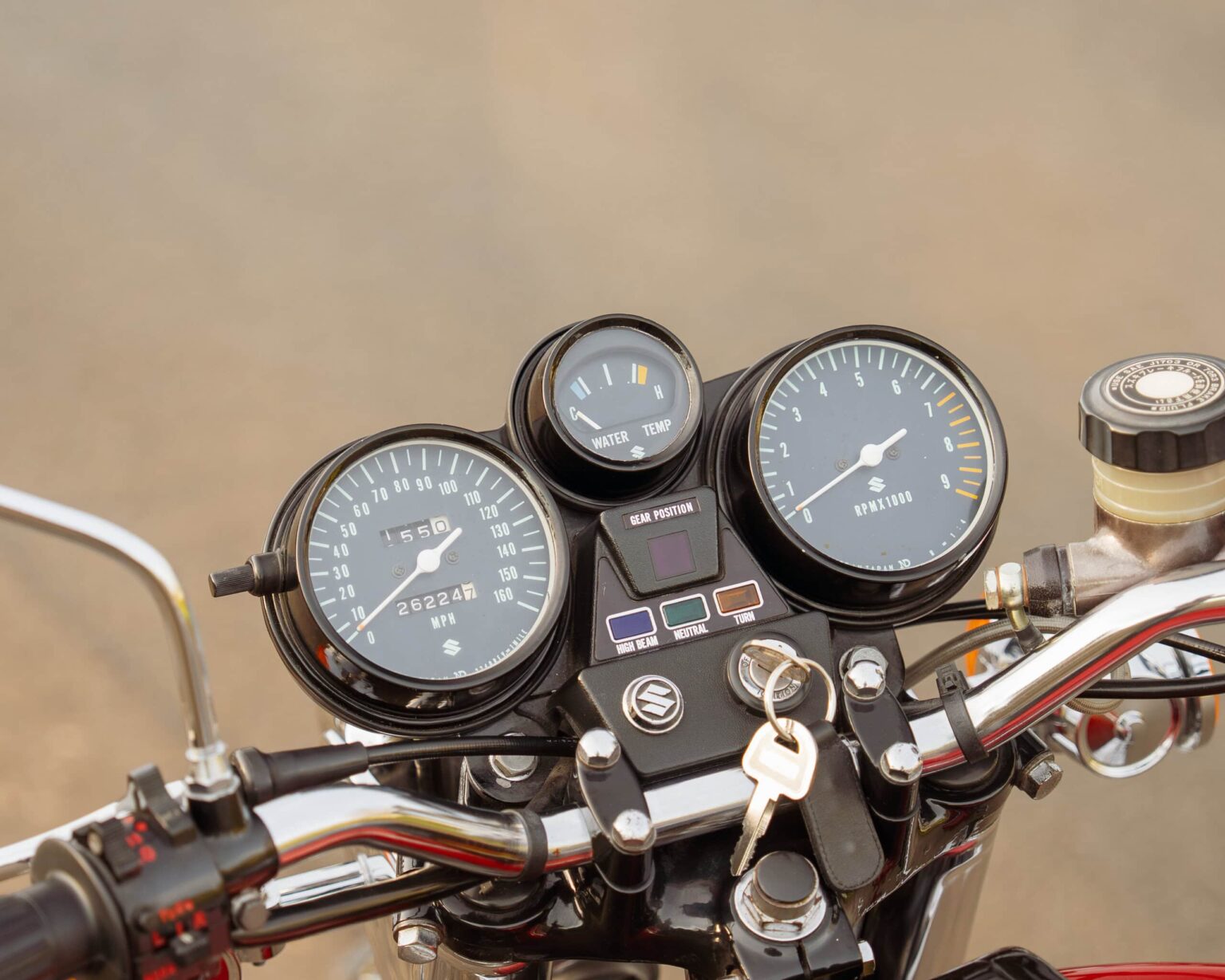 Motorcycle dashboard with speedometer, tachometer, and fuel gauge, highlighting vintage bike instrumentation.