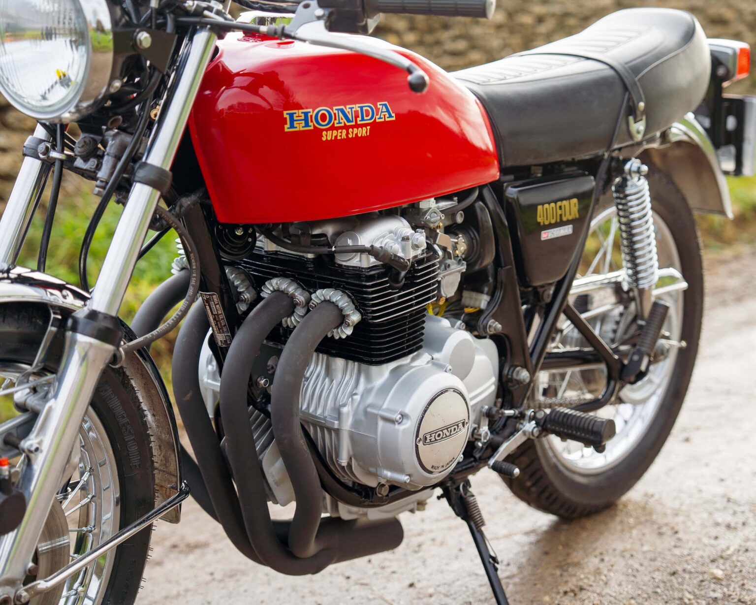 Vintage Honda motorcycle with red fuel tank and black seat, showcasing classic styling and engineeri.