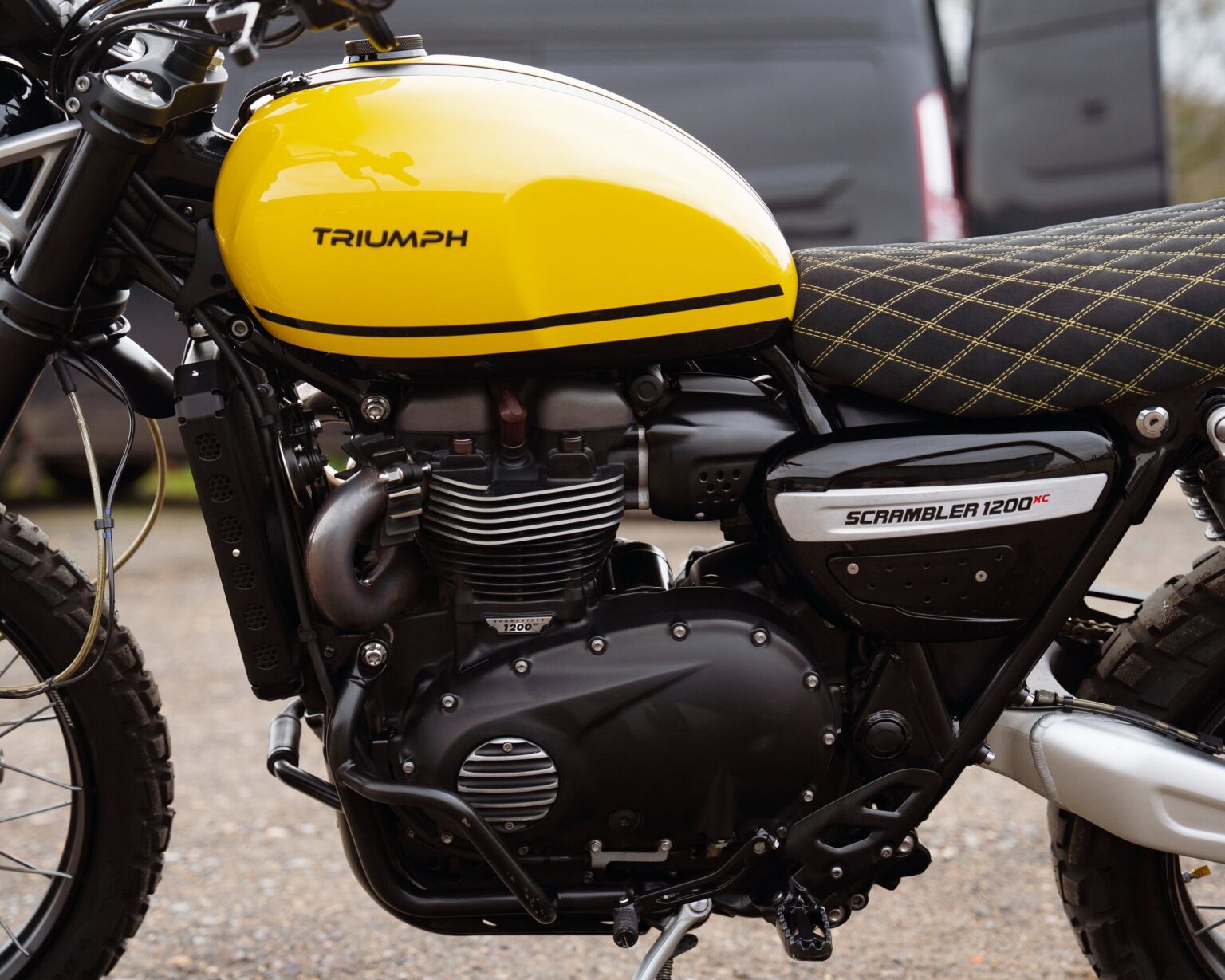 Yellow Triumph Scrambler 1200 motorcycle with black engine and seat.