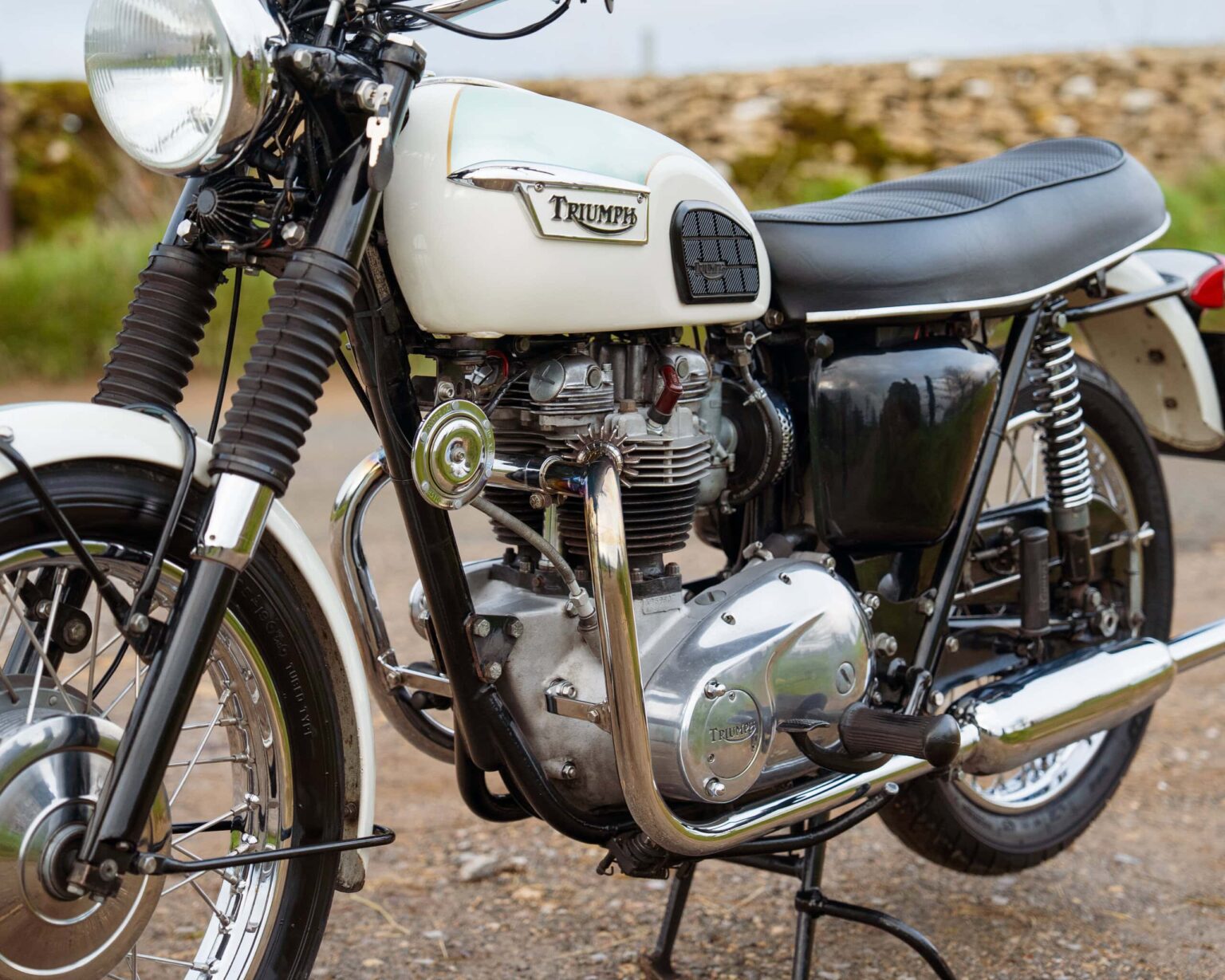 Vintage Triumph motorcycle in outdoor setting.