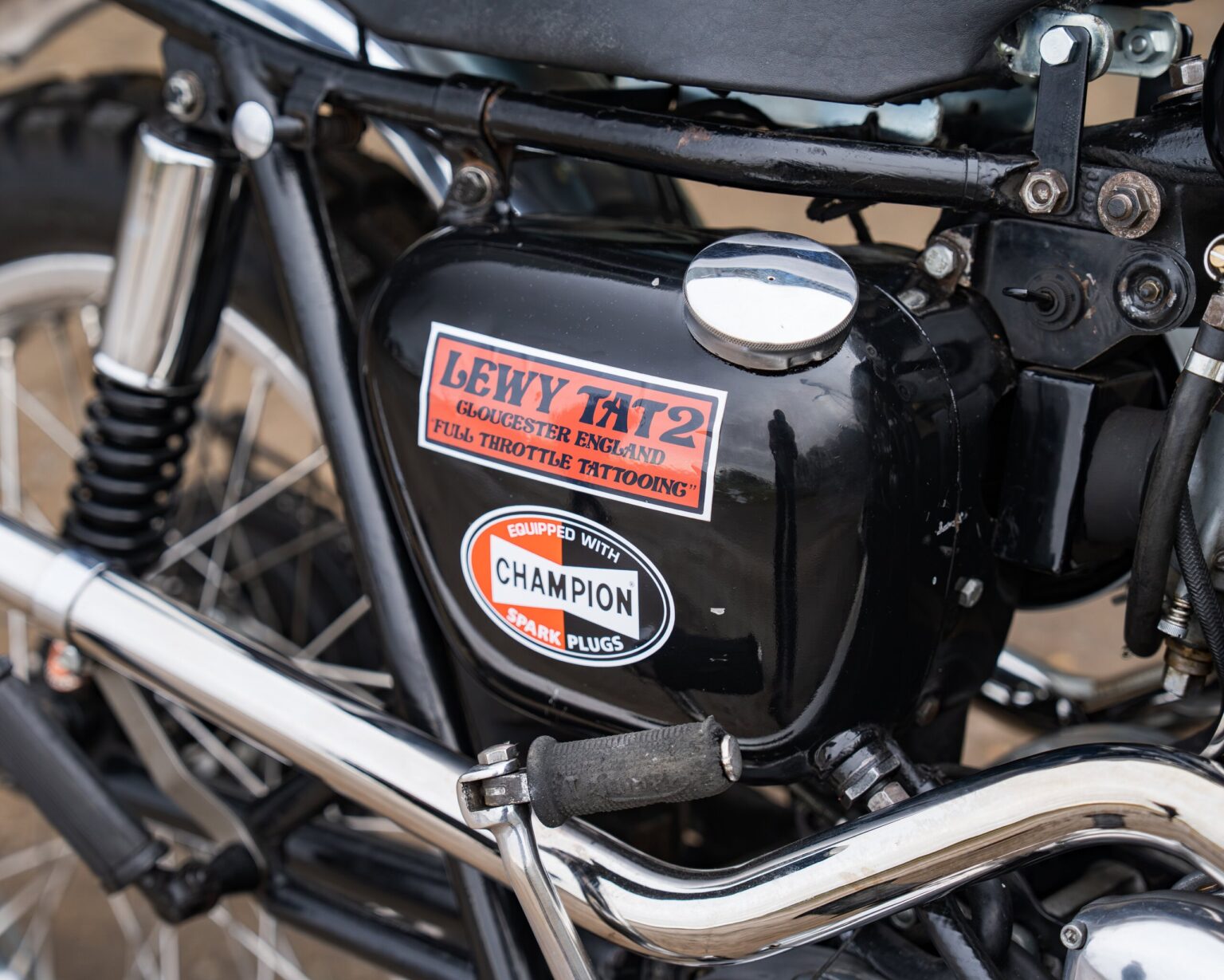 Classic motorcycle engine with racing stickers and chrome accents.