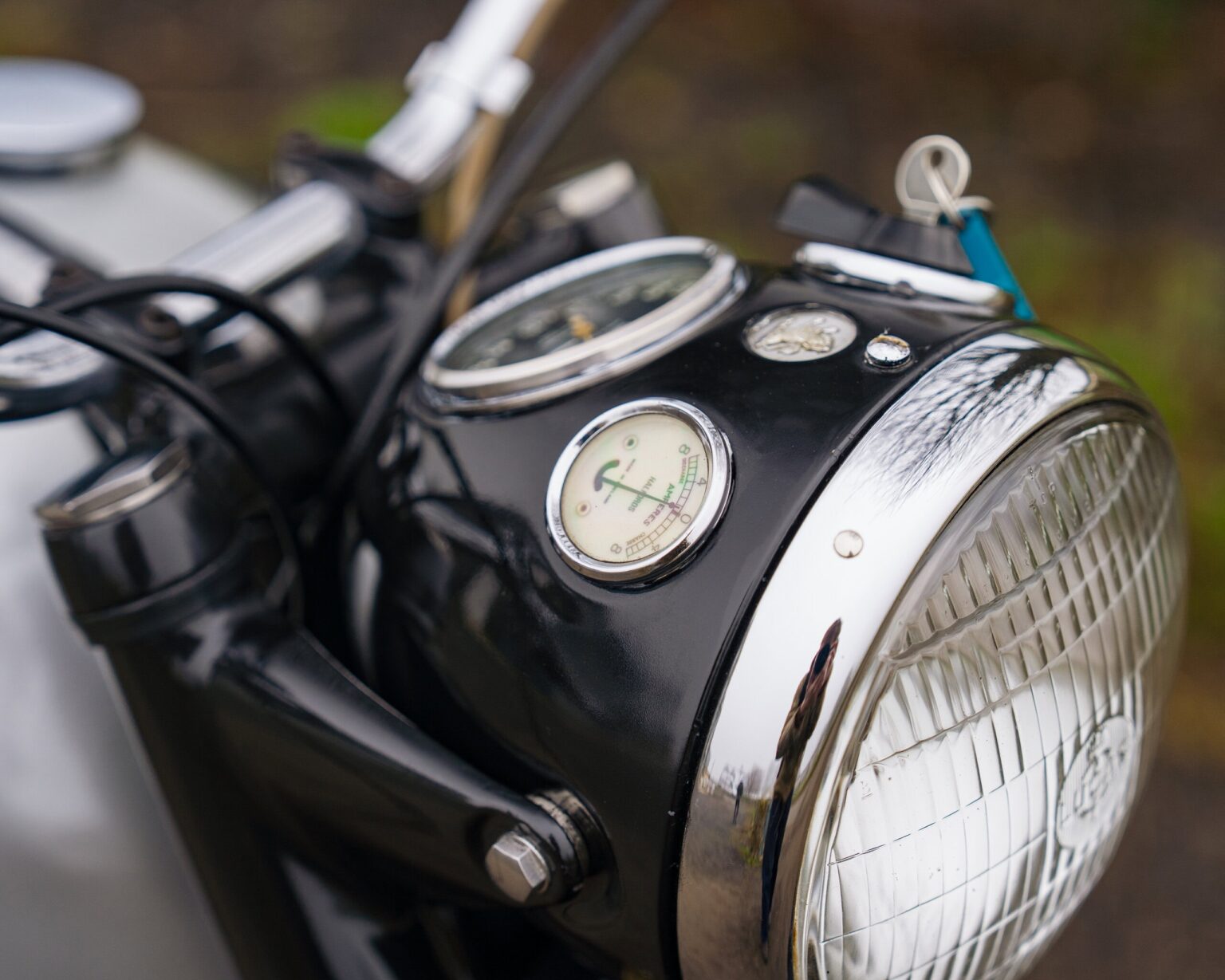 Motorcycle headlamp with speedometer and controls, close-up shot.
