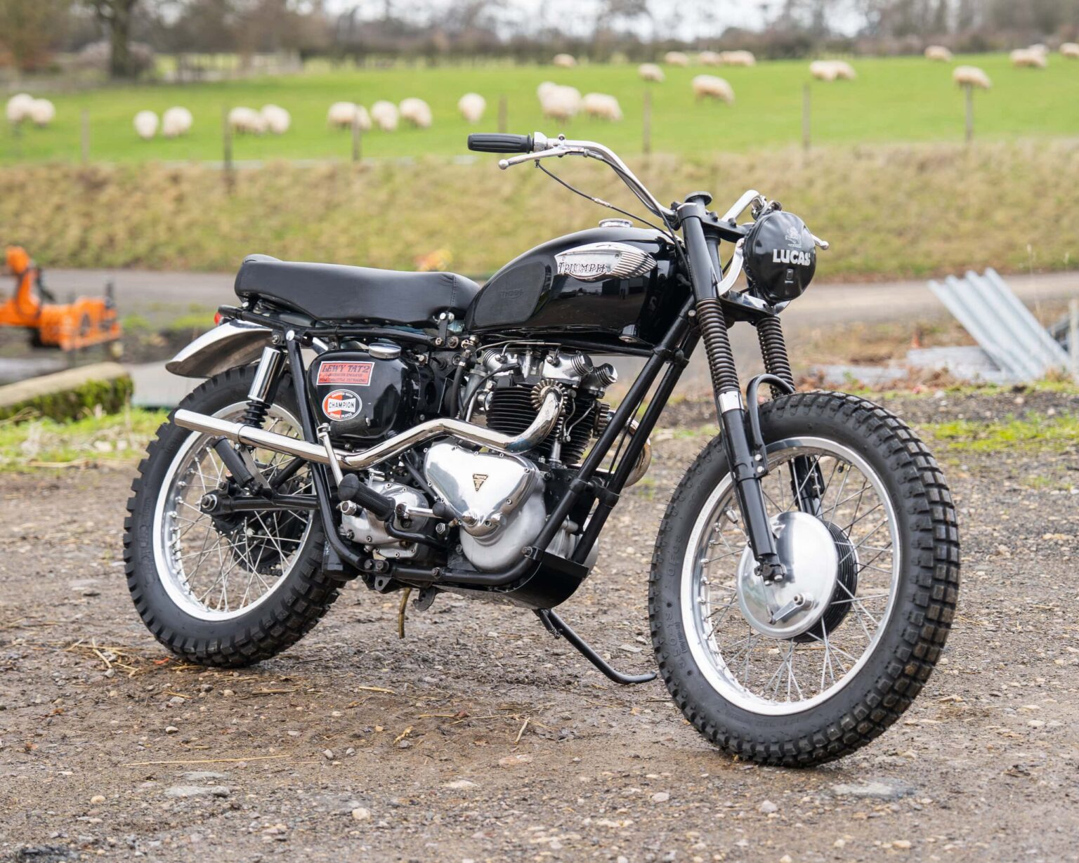Vintage black motorcycle with rugged tires and retro design.