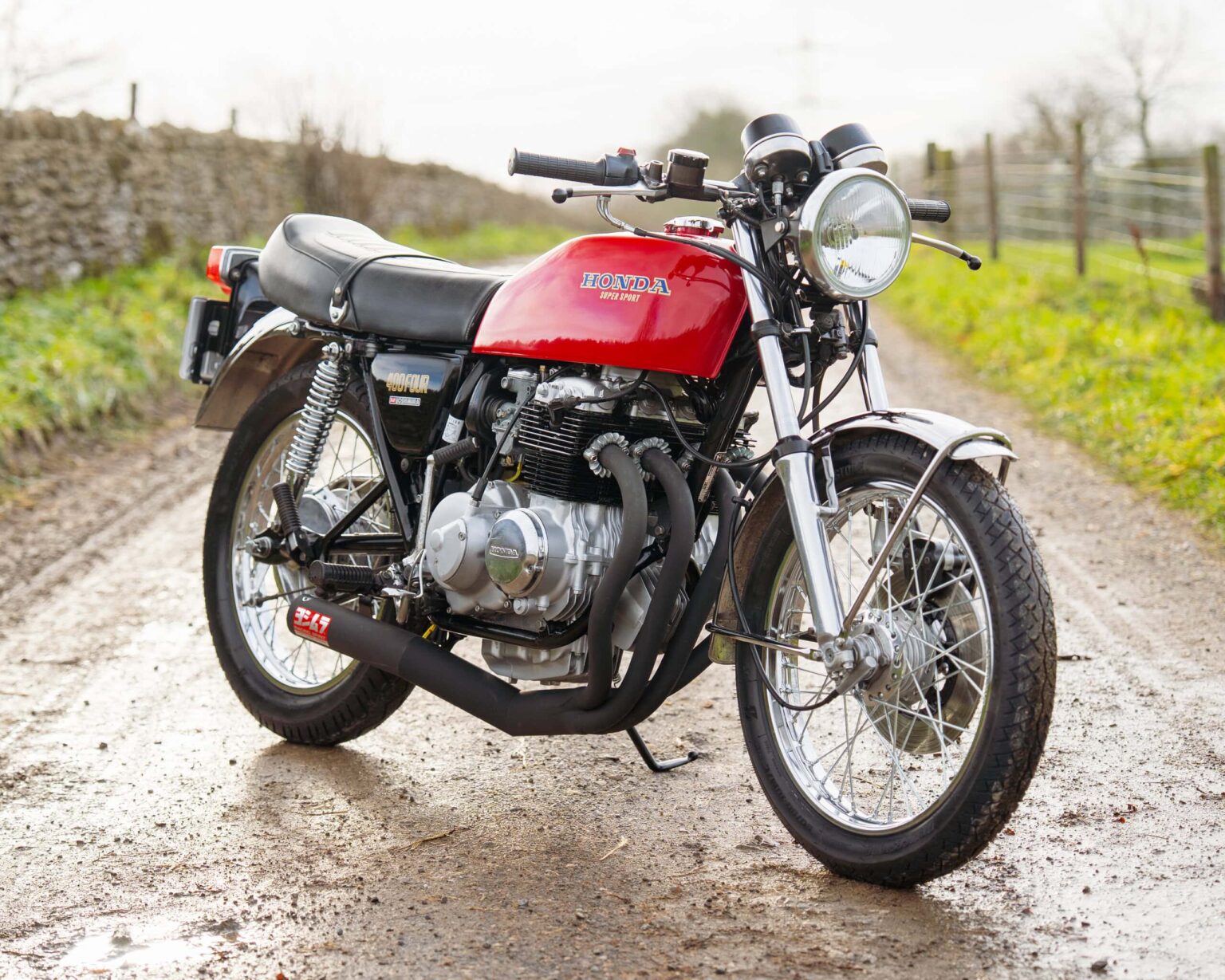 Vintage Honda CB750 motorcycle parked on a rural dirt road.