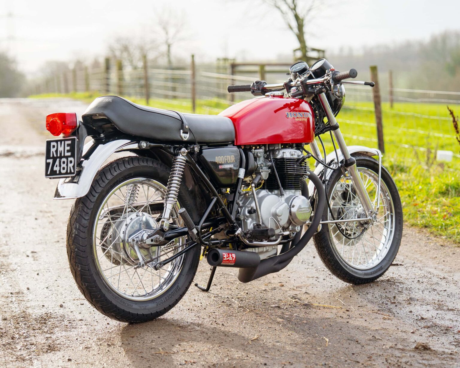 Vintage red motorcycle parked on a rural country road.