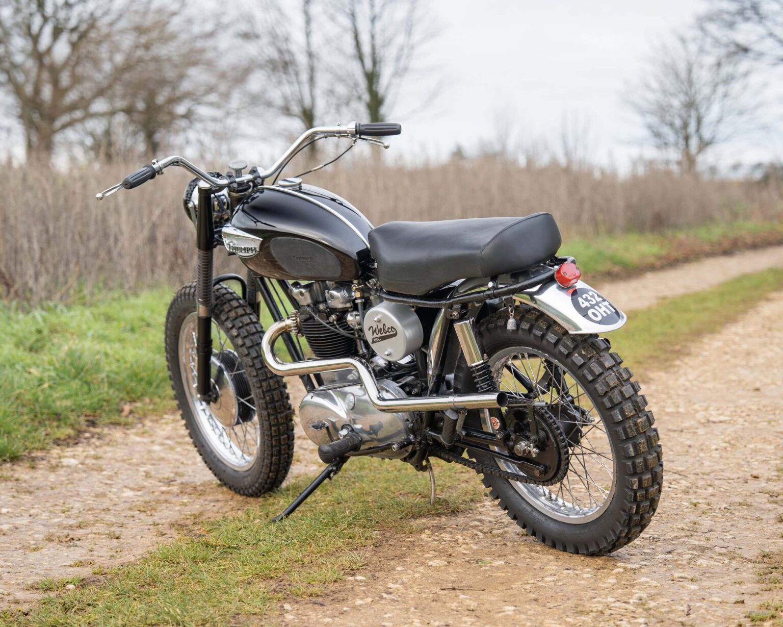 Road motorcycle with knobby tires and vintage design.