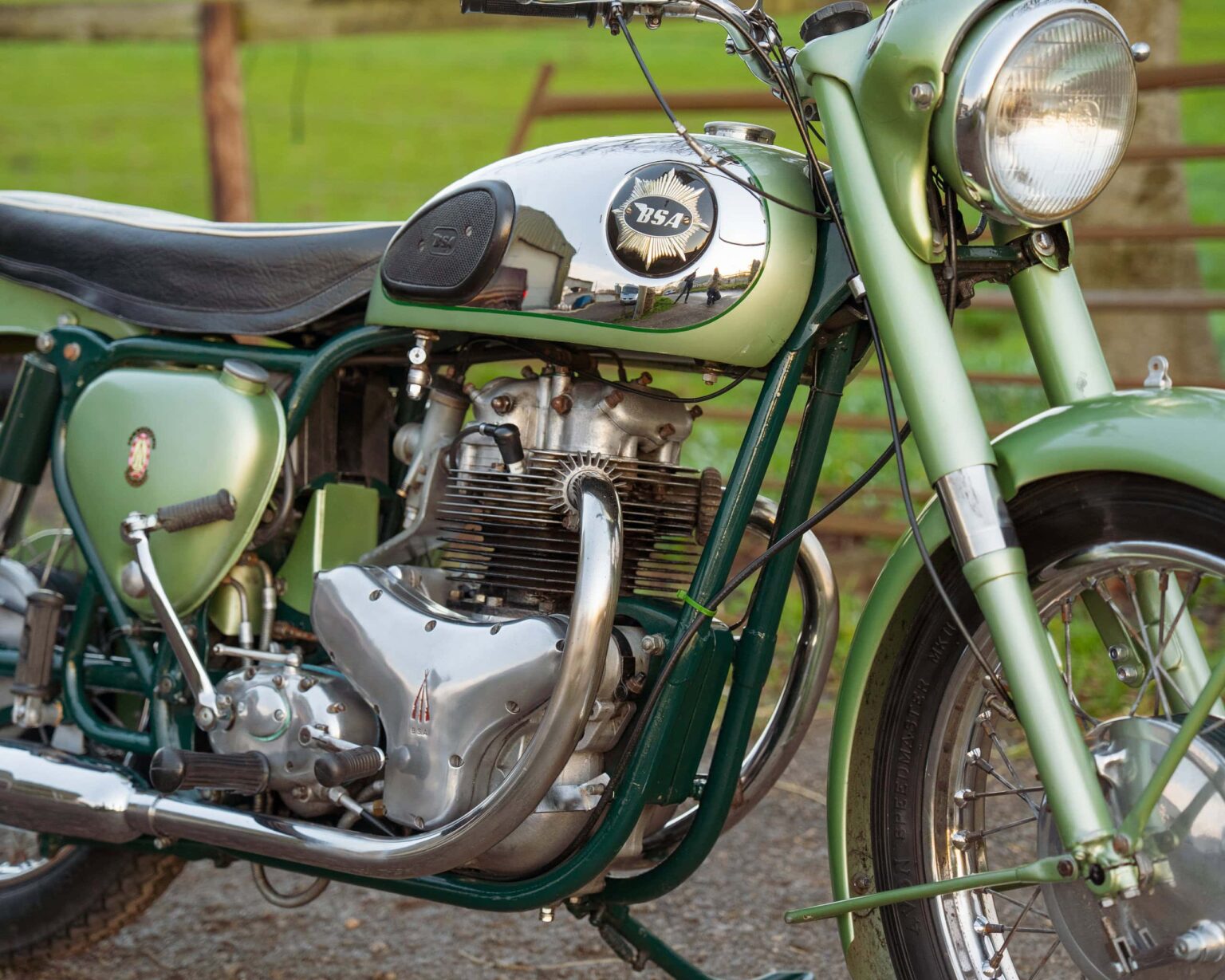 Vintage green motorcycle with chrome details and black seat.