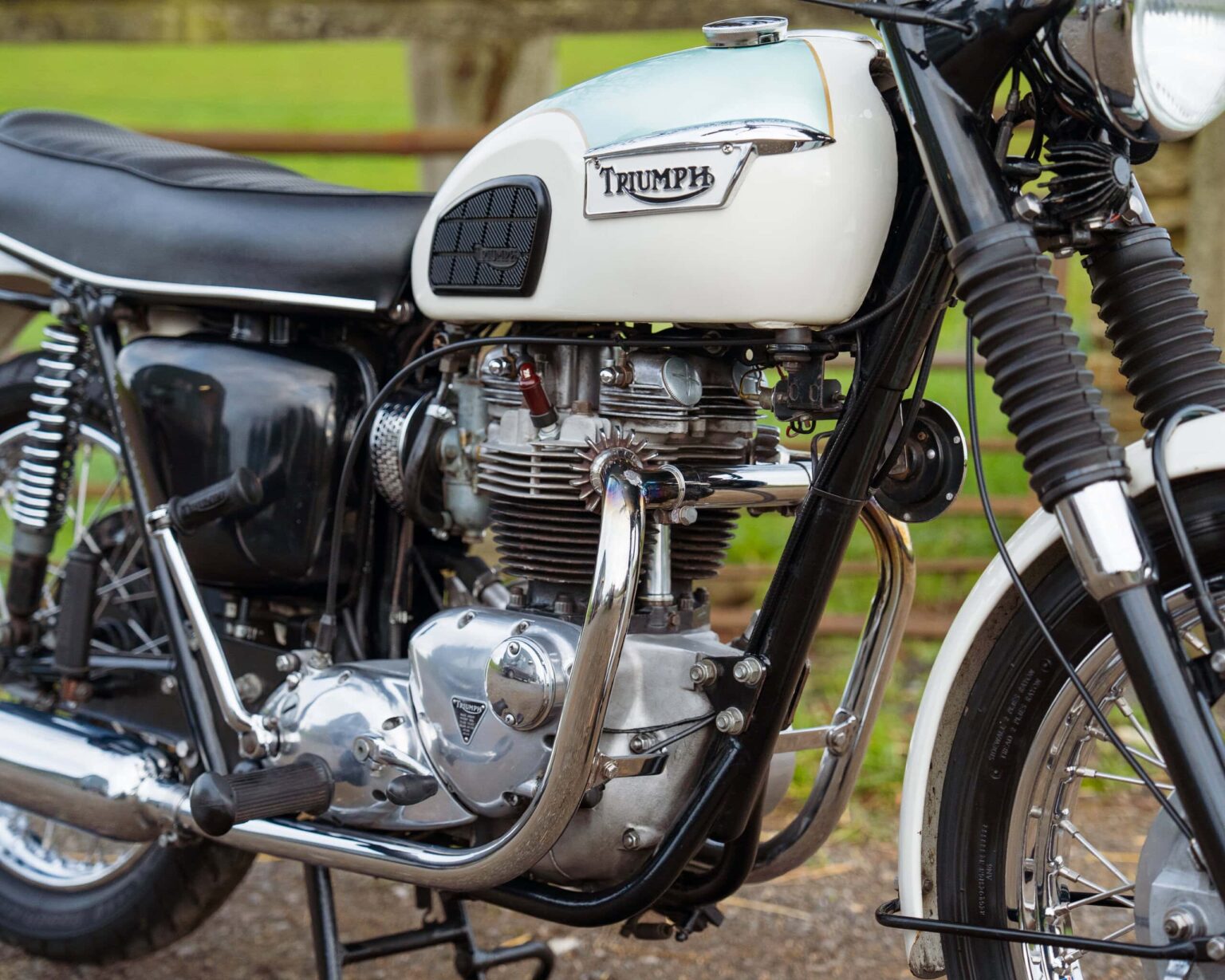 Vintage Triumph motorcycle with detailed engine and black and white colour scheme.