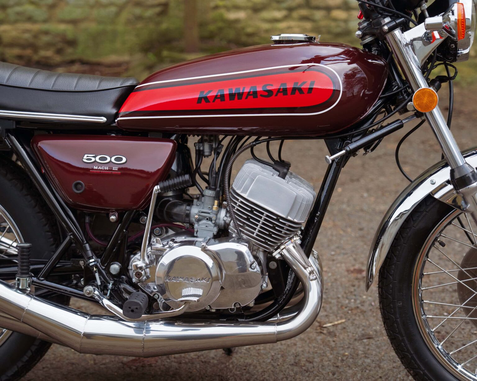 Vintage Kawasaki motorcycle with a red and black tank and chrome engine.