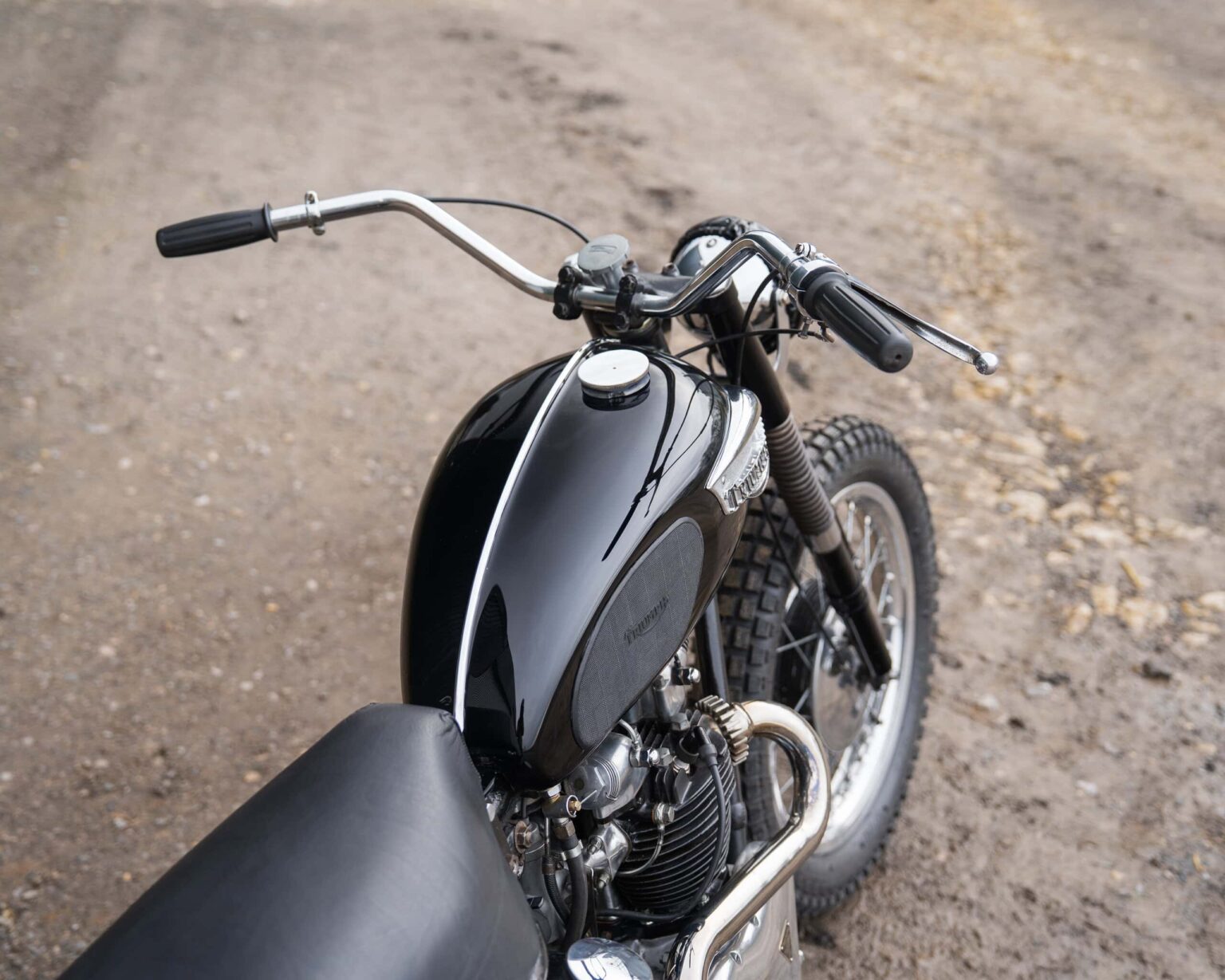 Motorcycle with black fuel tank and vintage design.