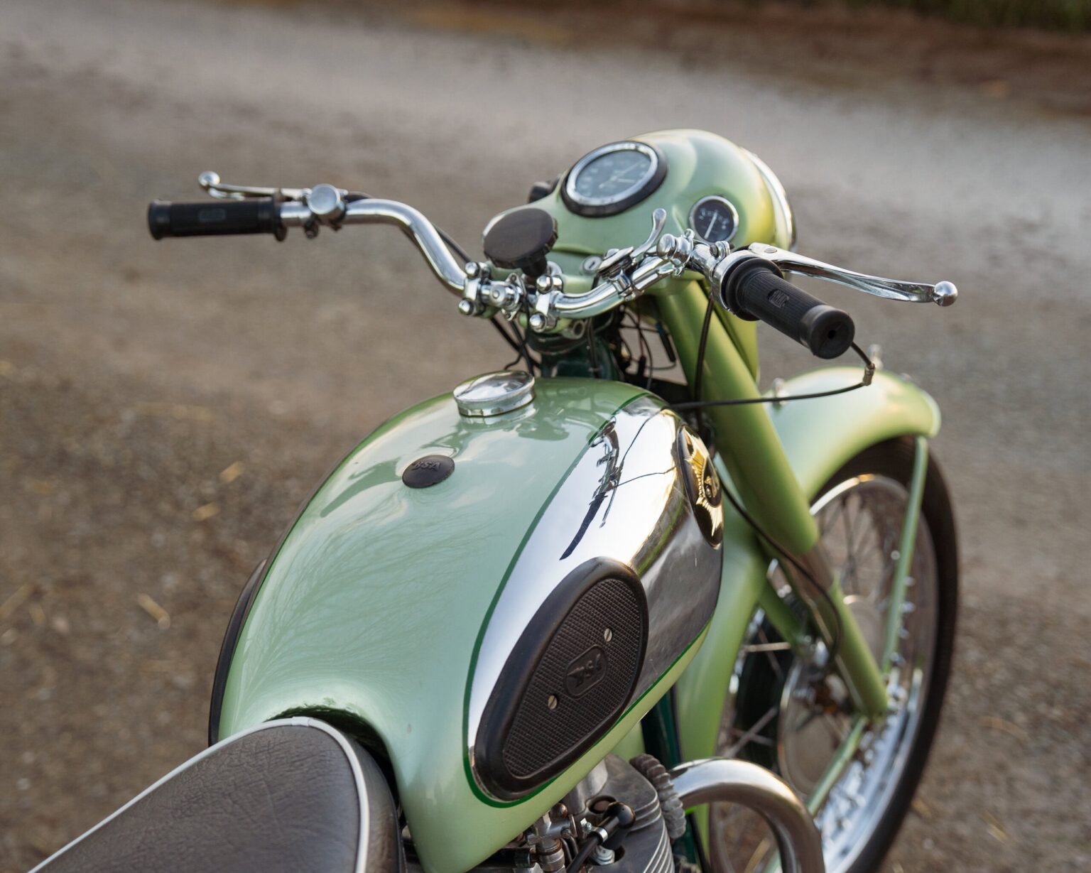 Motorcycle with a vintage green and black design, parked outdoors.