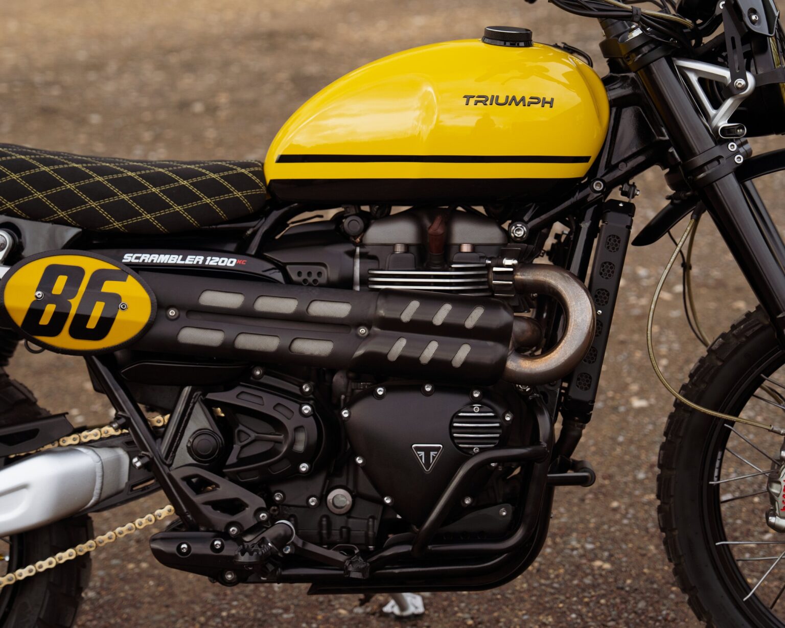 Triumph Scrambler 1200 motorcycle with yellow fuel tank and custom details.