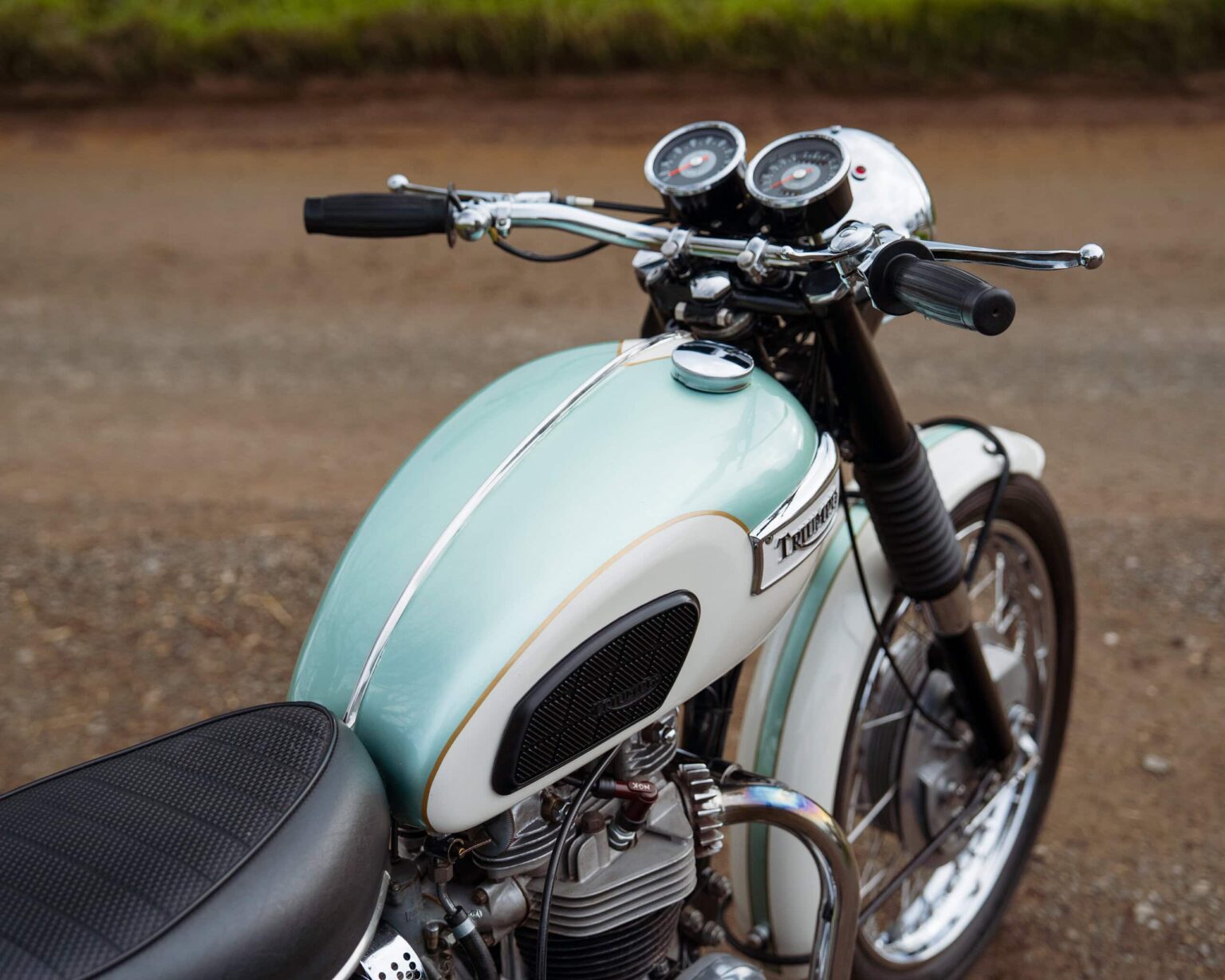 Vintage motorcycle with a light blue and white colour scheme, featuring a sleek design and chrome de.